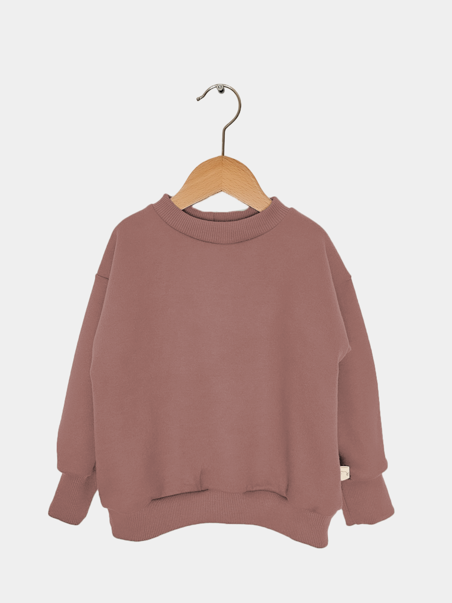 Pulli Bio-Sweat - Zimt auf einem Holzbügel, aus Bio-Baumwolle, kuschelig weich, perfekt für Kinder, wächst mit, hergestellt in Berlin.