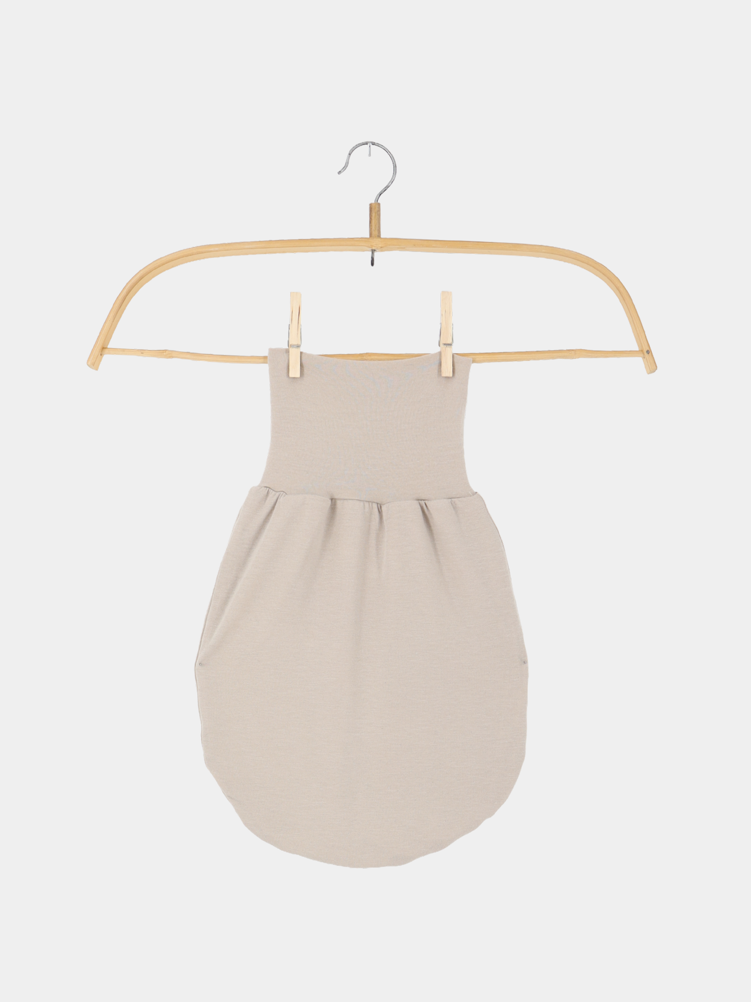 Baby Strampel- und Pucksack Kaschmir-Mix Sand hängt an einem Holzkleiderbügel, zeigt seine weiche, beige Struktur. Ideal als Schlaf- oder Strampelsack, bietet Wärme und Komfort für Neugeborene.