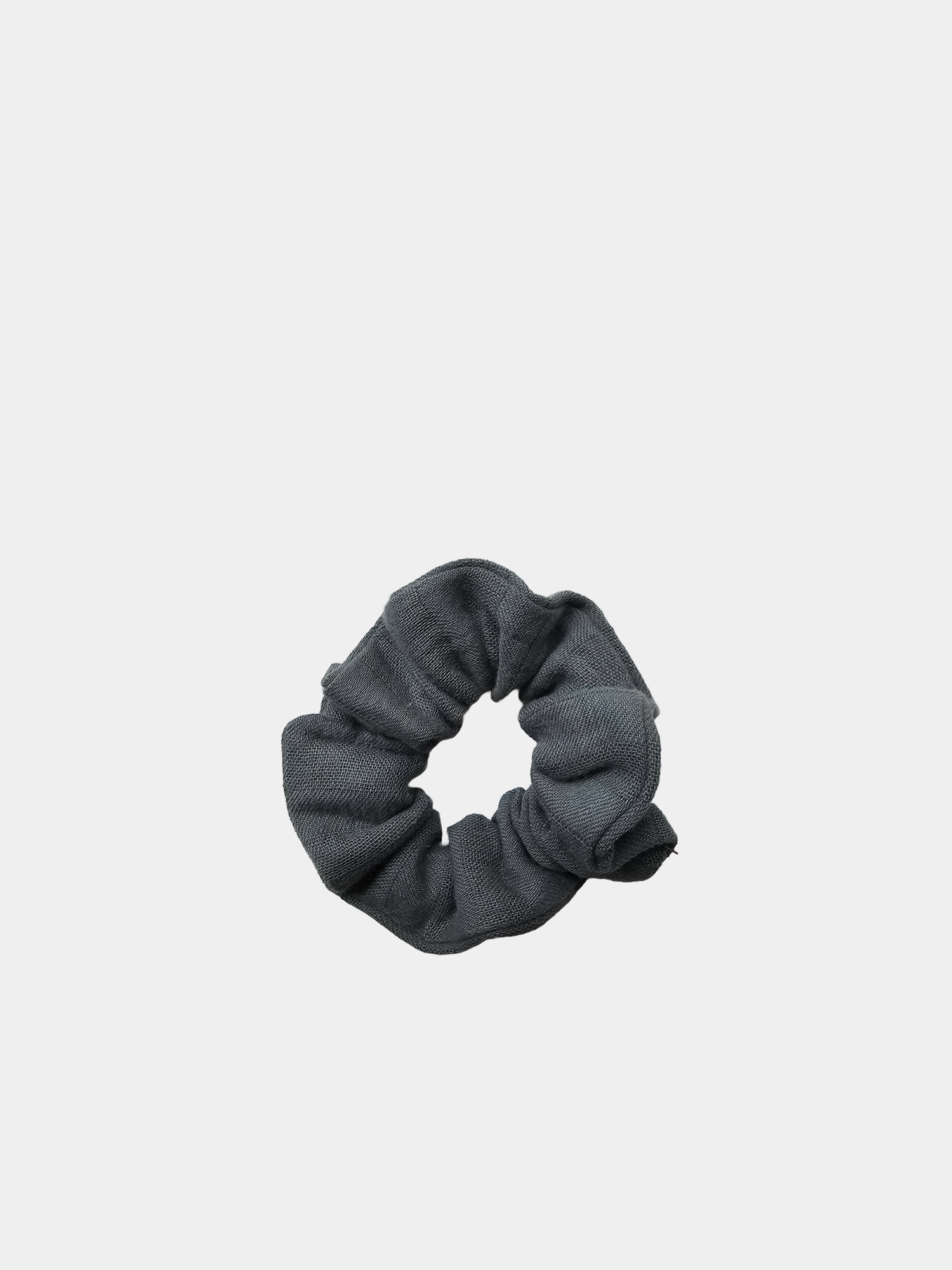 Graues Upcycling-Scrunchie aus Bio-Musselin, präsentiert vor neutralem Hintergrund. nachhaltige Kinderkleidung