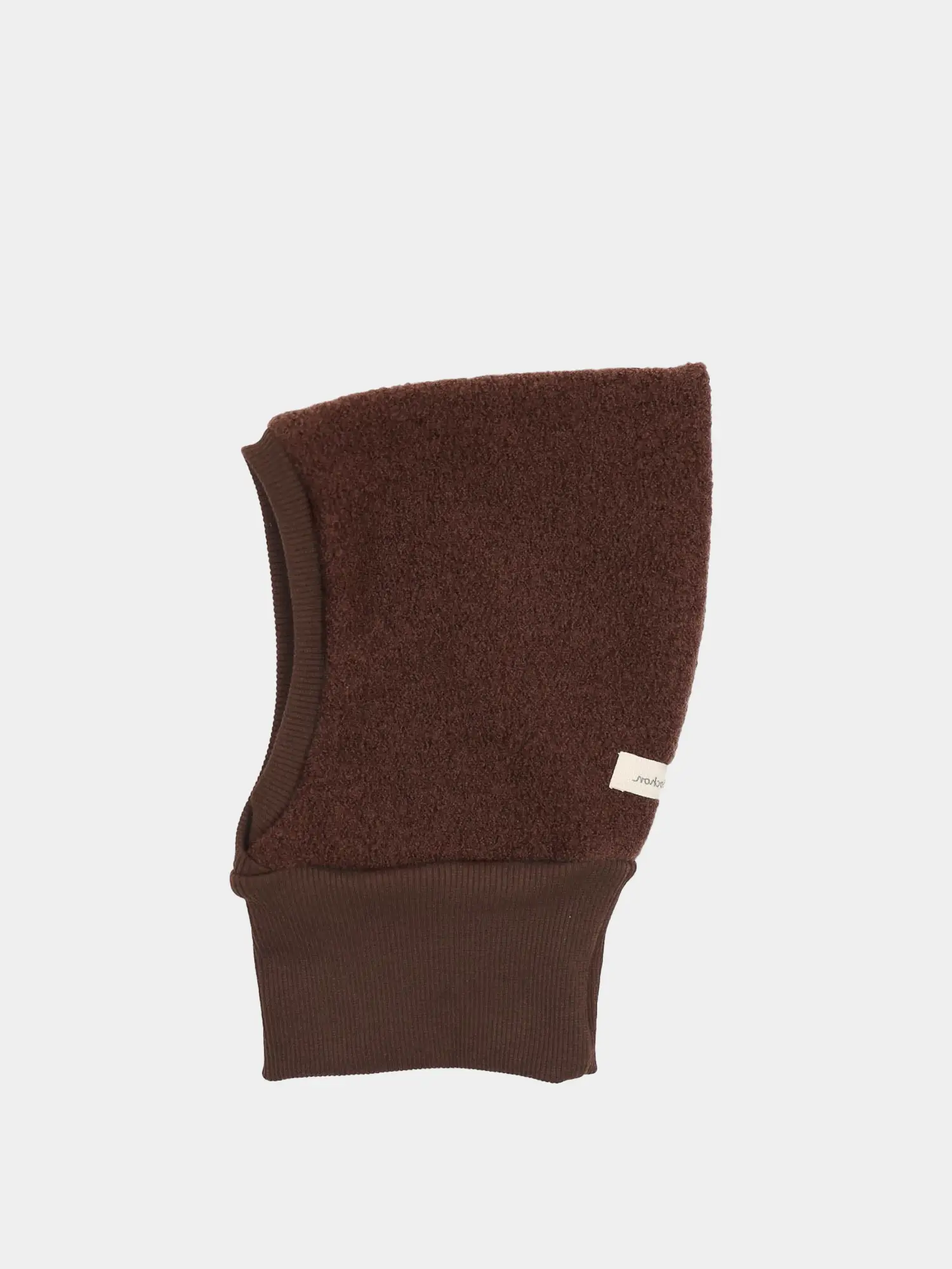 Schlupfmütze Wollwalk - Schoko: Flach liegende braune Wollwalk-Schlupfmütze mit weichem Teddy-Fleece-Oberteil und geripptem Strickbund, seitlich mit kleinem Stoffetikett versehen.