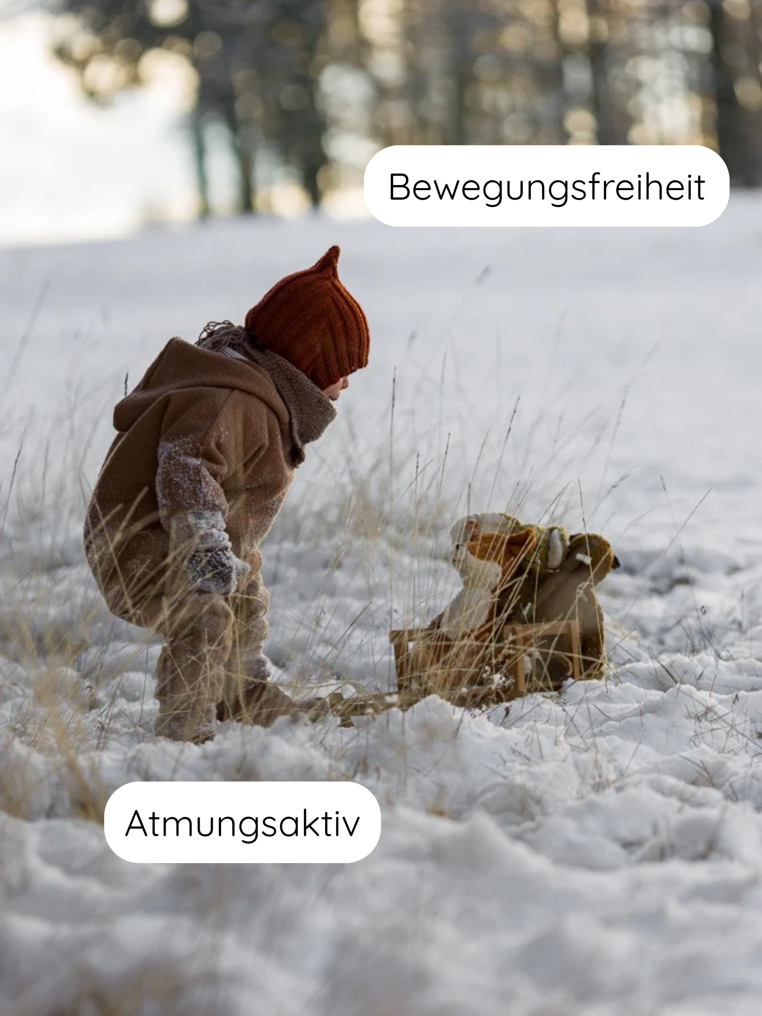 Kleinkind im Schnee mit Teddy-Wichteljacke Wollwalk - Schoko, kniet neben Schlitten mit Plüschtier, zeigt Bewegungsfreiheit und Atmungsaktivität; ideal für kalte Tage.