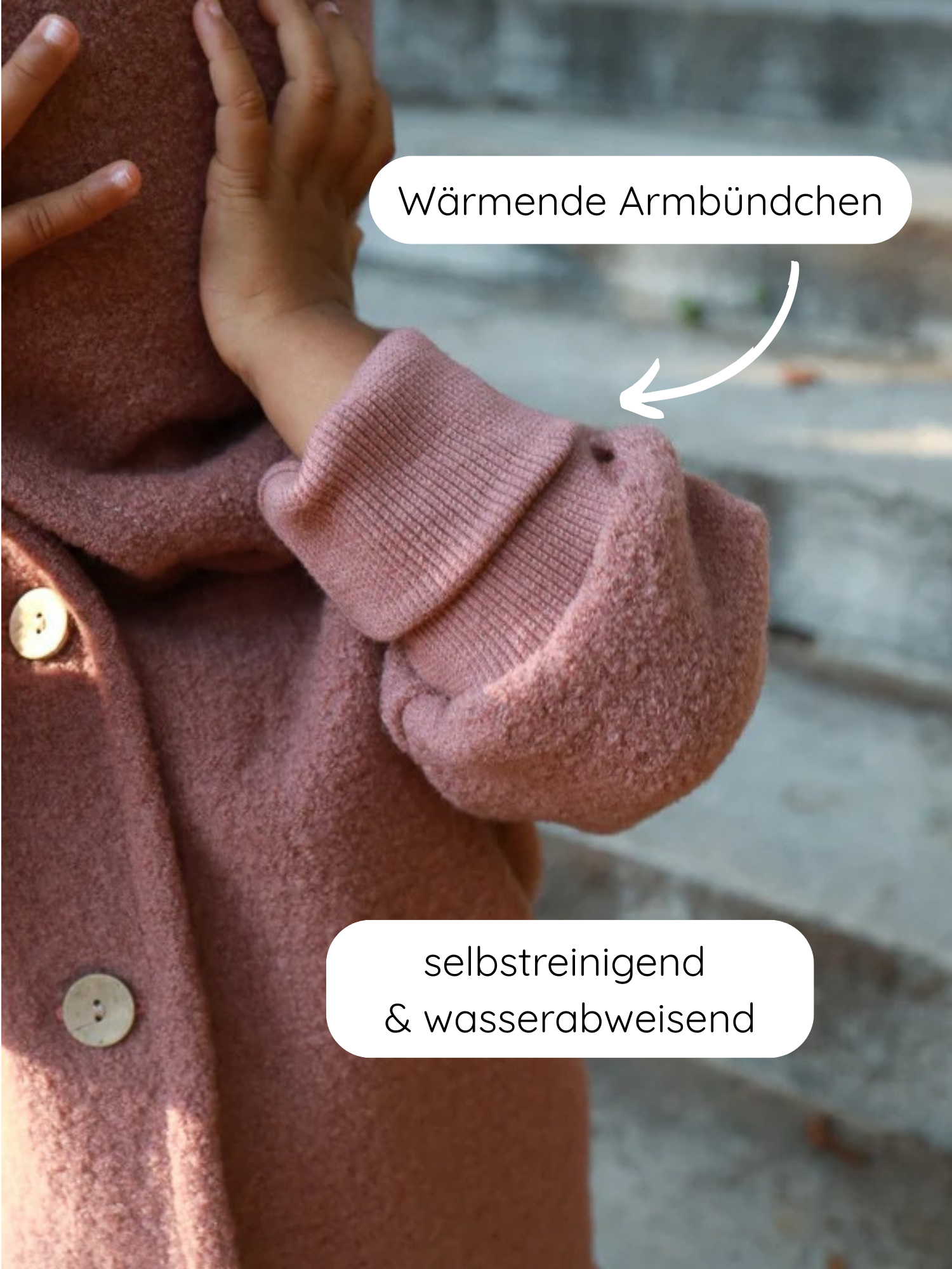 Nahaufnahme der Wichteljacke Wollwalk - Zimt: Staubrosane Kinderjacke mit großen Knopf, gerippten, umklappbaren Bündchen und bouclé-ähnlichem Stoff, der selbstreinigend und wasserabweisend ist.
