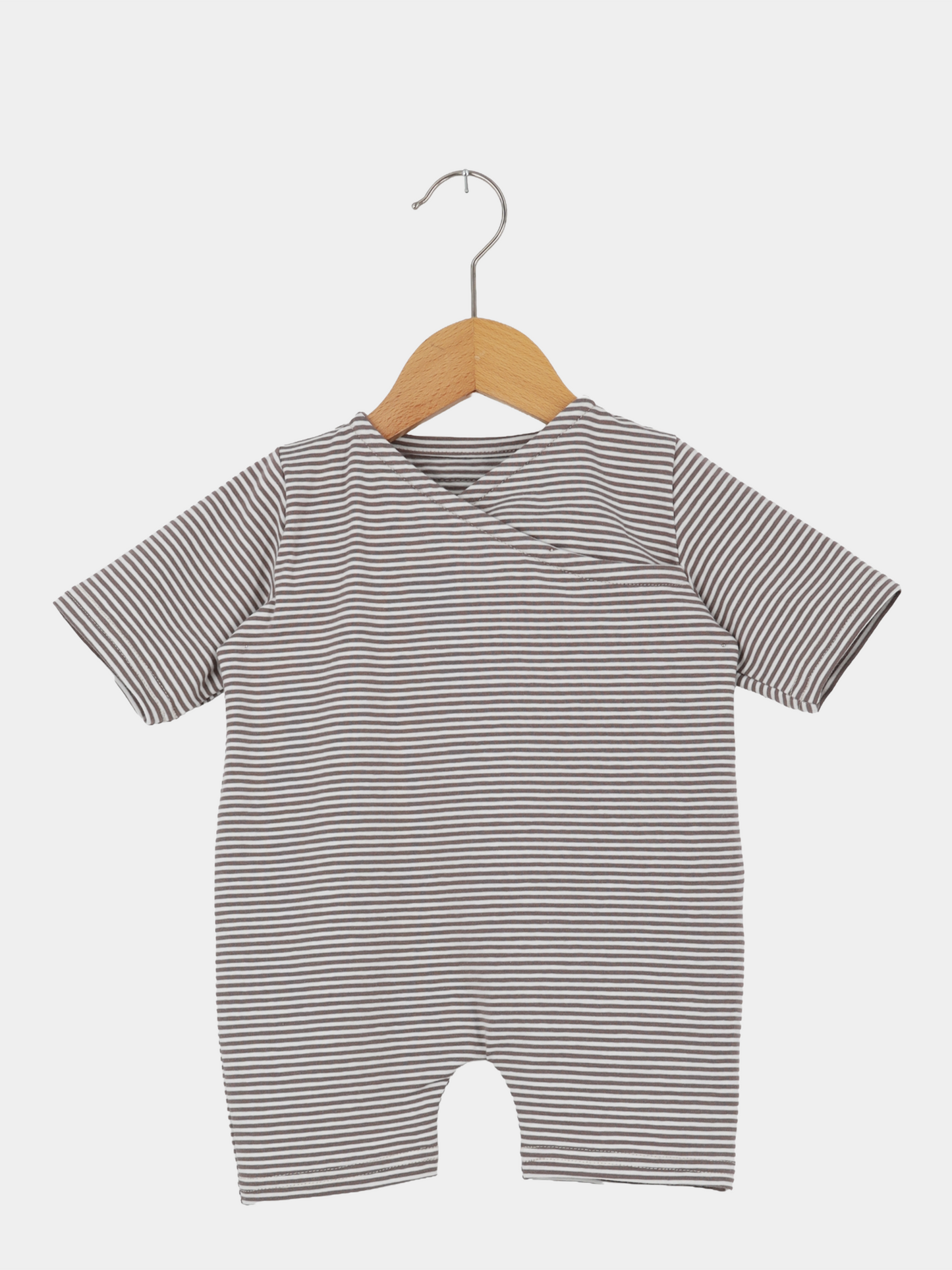 Wickel Overall Baumwolle - Ringel Praline: Kurzärmeliger Baby-Body mit schmalen grauen und weißen Streifen, aus weichem Baumwoll-Jersey, hängt an einem Holzkleiderbügel vor weißem Hintergrund.