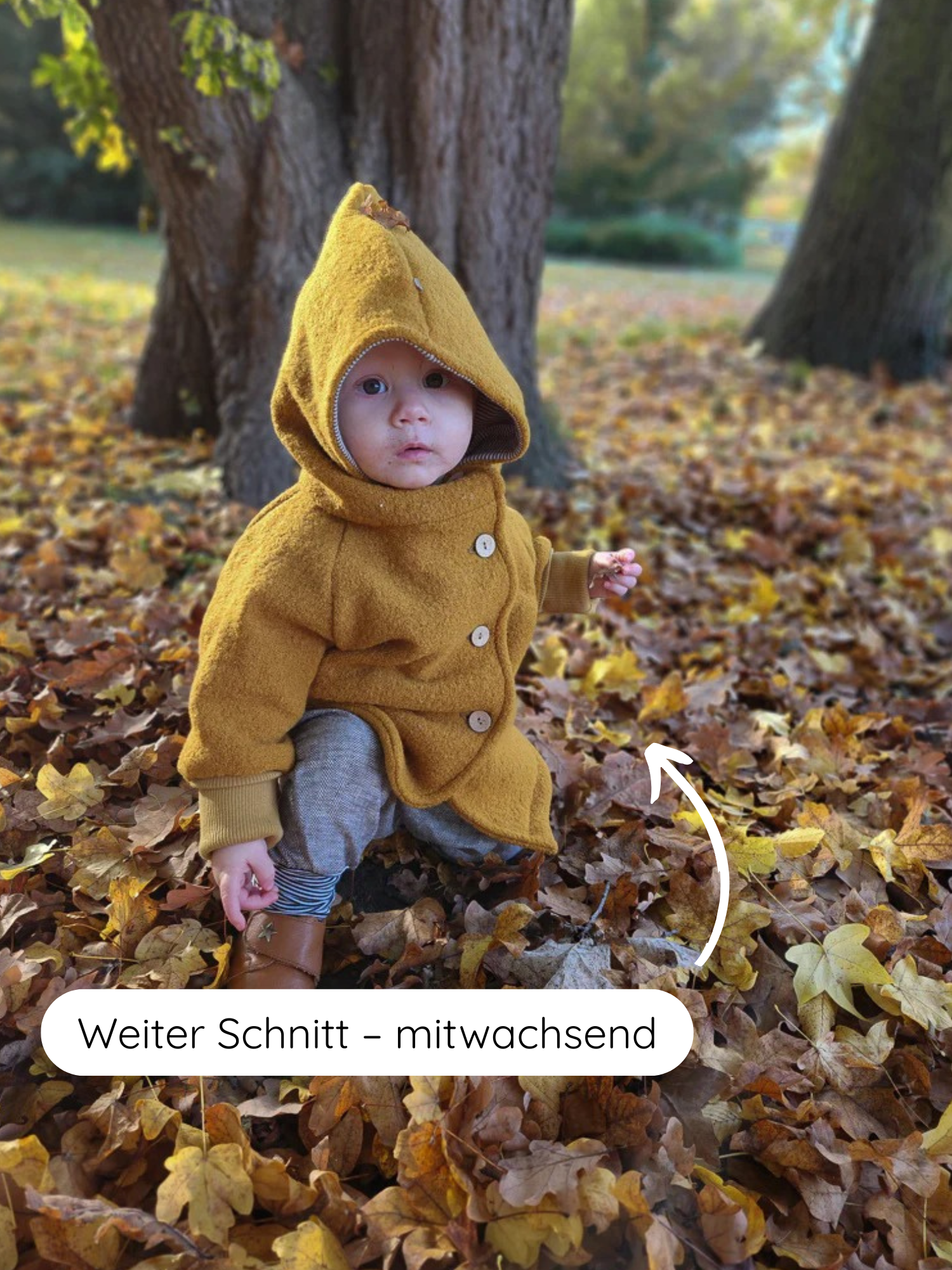 Kleinkind in Wollwalk-Wichteljacke Honig, trägt eine gelbe Kapuzenjacke mit Holzknöpfen, ideal für Herbst bis Frühling, mitwachsend und gefüttert, im Laub spielend.