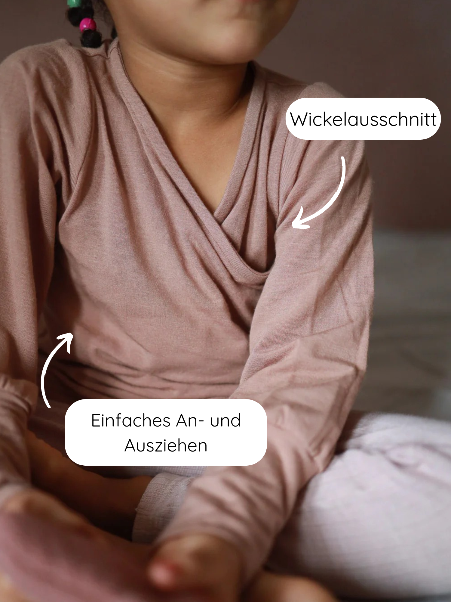 Wickelshirt aus Kaschmir-Mix - Puder zeigt ein Kind im Wickelausschnitt-Top, das einfaches An- und Ausziehen ermöglicht. Der Schnitt ist mitwachsend, handgefertigt in Berlin, aus atmungsaktivem, temperaturregulierendem Stoff.
