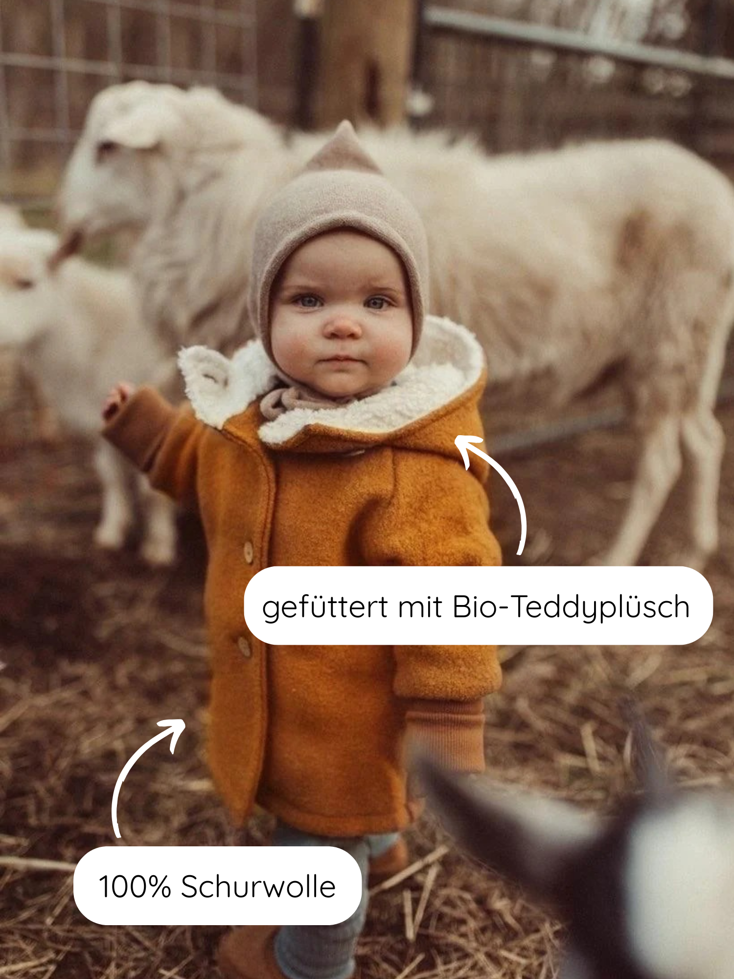 Ein Kleinkind trägt die Winter Wichteljacke Wollwalk mit Teddyfutter - Honig, erkennbar an der spitzen Kapuze. Der Mantel besteht aus 100 % Schurwolle, gefüttert mit Bio-Teddyplüsch.