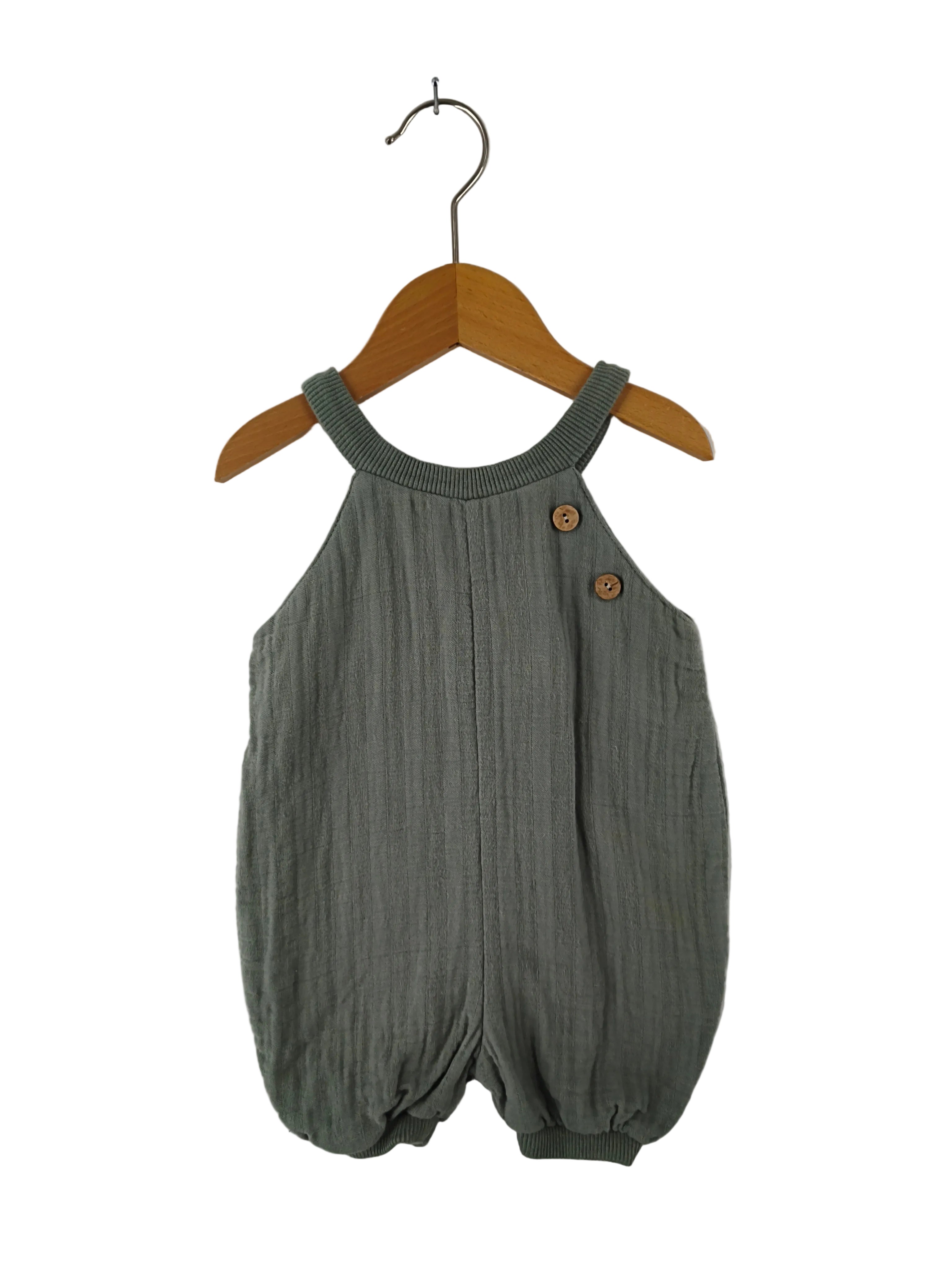 (Kopie) Kurze Schlupflatzhose Musselin Aqua Gr 3M: Ärmelloser Babystrampler aus weichem, leicht geknittertem Stoff, mit geripptem Rundhalsausschnitt, zwei Holzknöpfen auf einer Schulter und elastischen Beinabschlüssen für eine sanfte Blasenform.