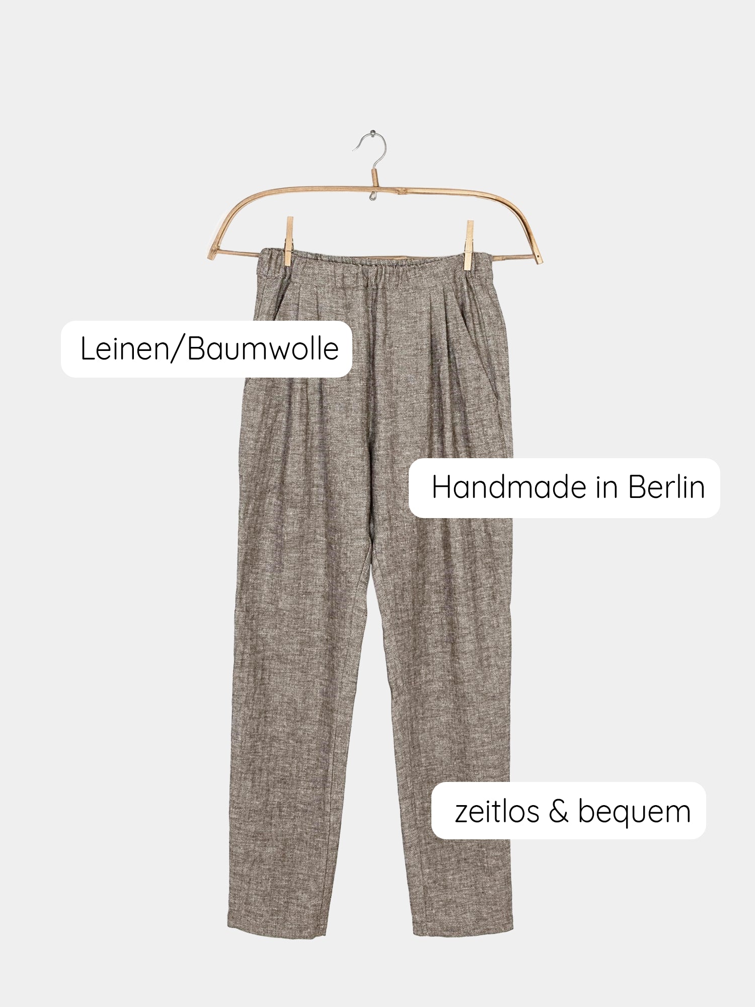 Bundfaltenhose Fischgrat auf einem Holzschwinger dargestellt, mit sichtbarer und deutlicher Textur des Fischgratsmusters.