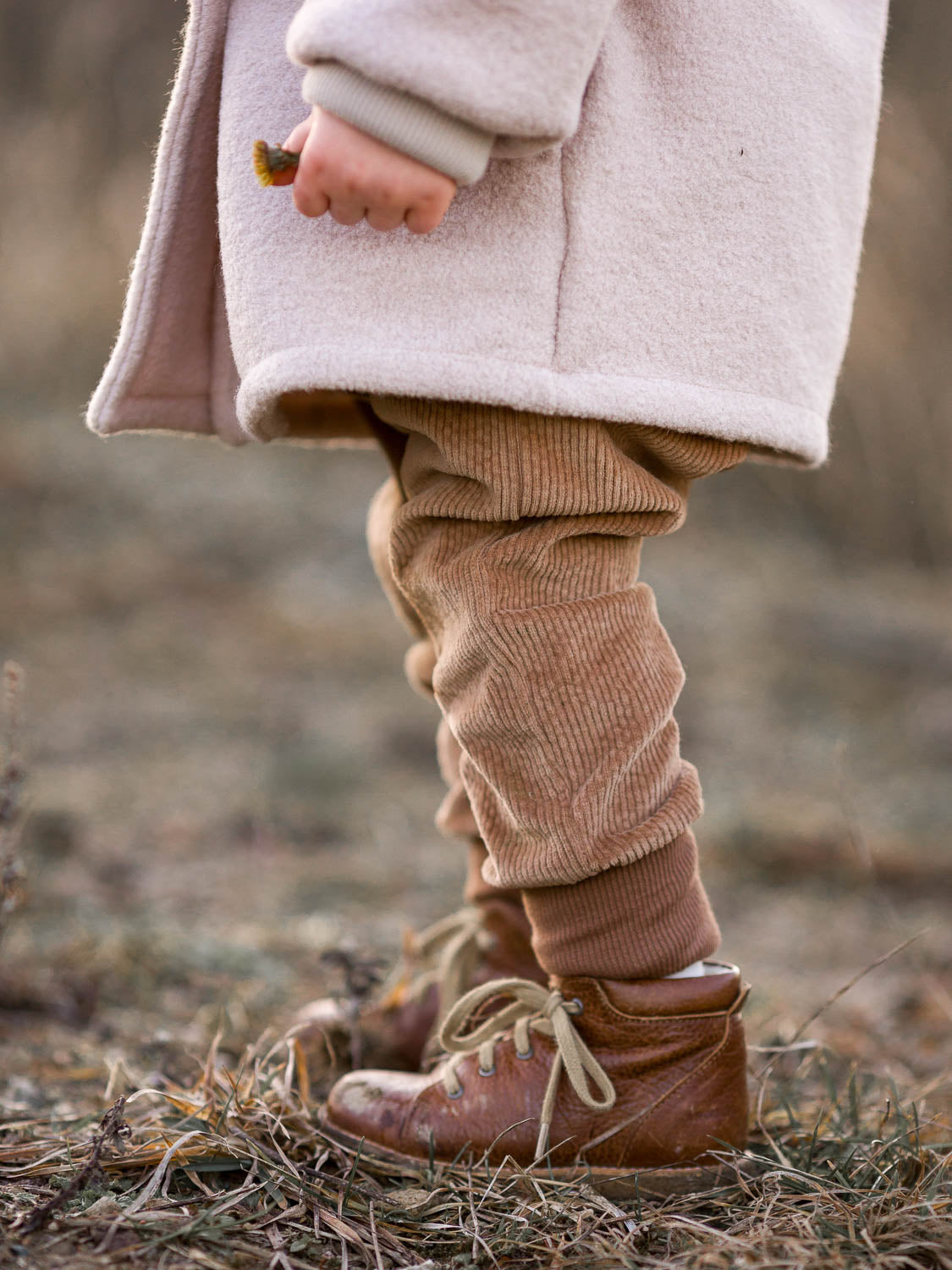 Knickerbocker Breitcord - Weizen: Kinderbeine in braunen Cordhosen mit weichem, elastischem Gewebe und großer Känguru-Tasche, ideal für Bewegungsfreiheit und Komfort.