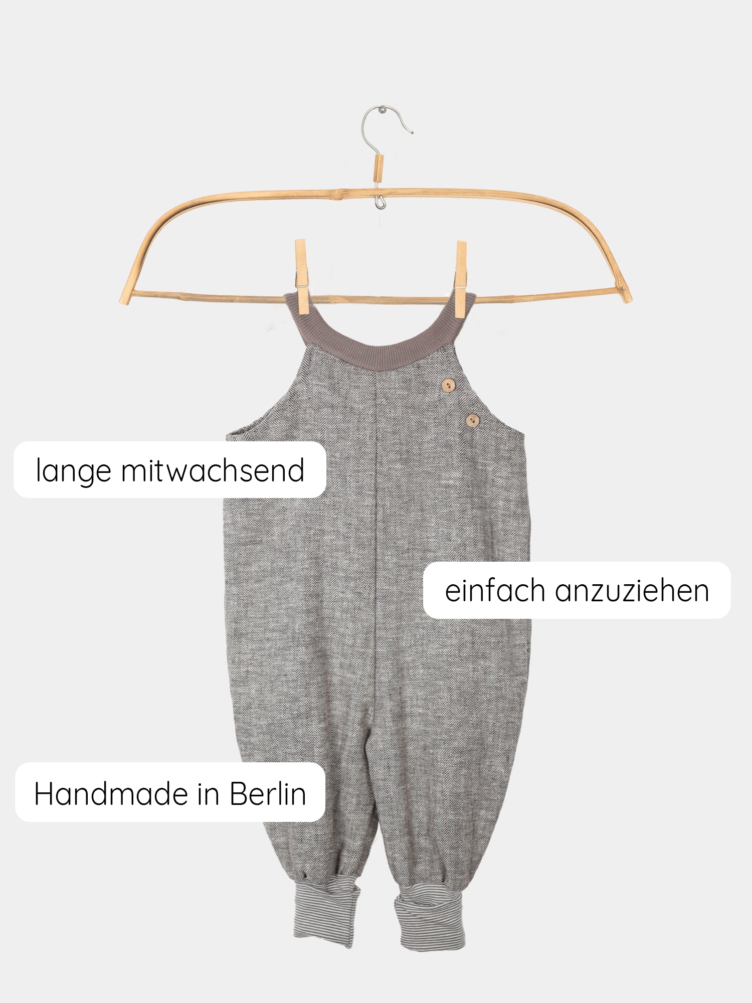 Schlupflatzhose aus Fischgrat auf einem Holzbügel präsentiert, zeigt robuste Leinen-Baumwoll-Mischung und Jerseybündchen mit feinen Streifen. Perfekt für Alltag und festliche Anlässe, handgenäht in Berlin.