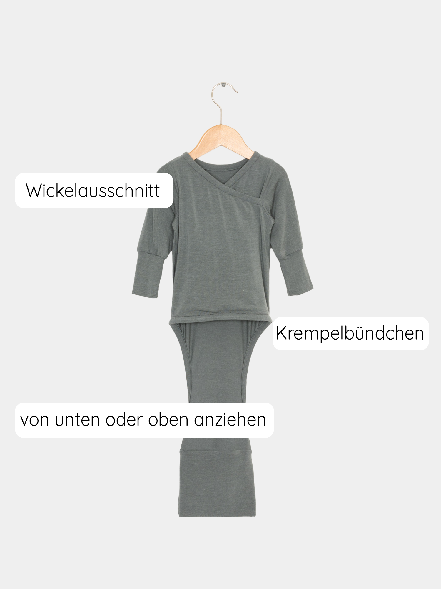 Loopbody Kaschmir-Mix - mitwachsender Babybody auf hölzernem Bügel, zeigt weichen, knopf- und nahtlosen Langarmbody mit innovativem Loop für einfaches An- und Ausziehen.