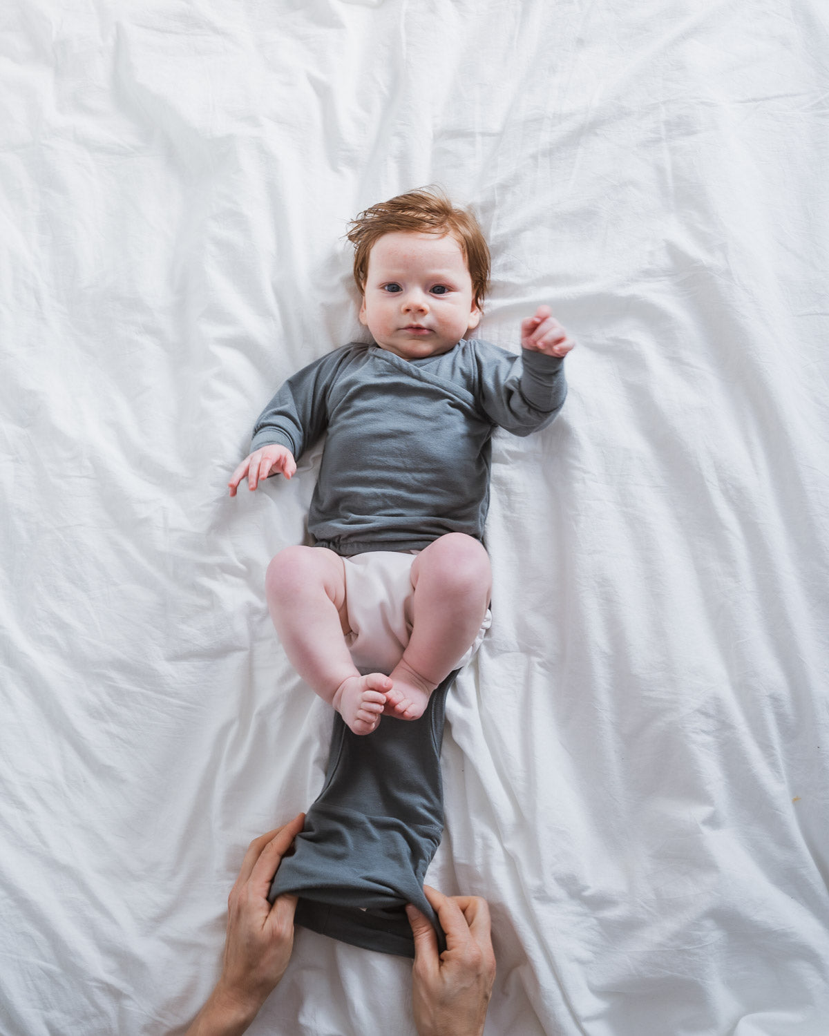 Wickeln eines Babys mit dem mitwachsenden Loopbody