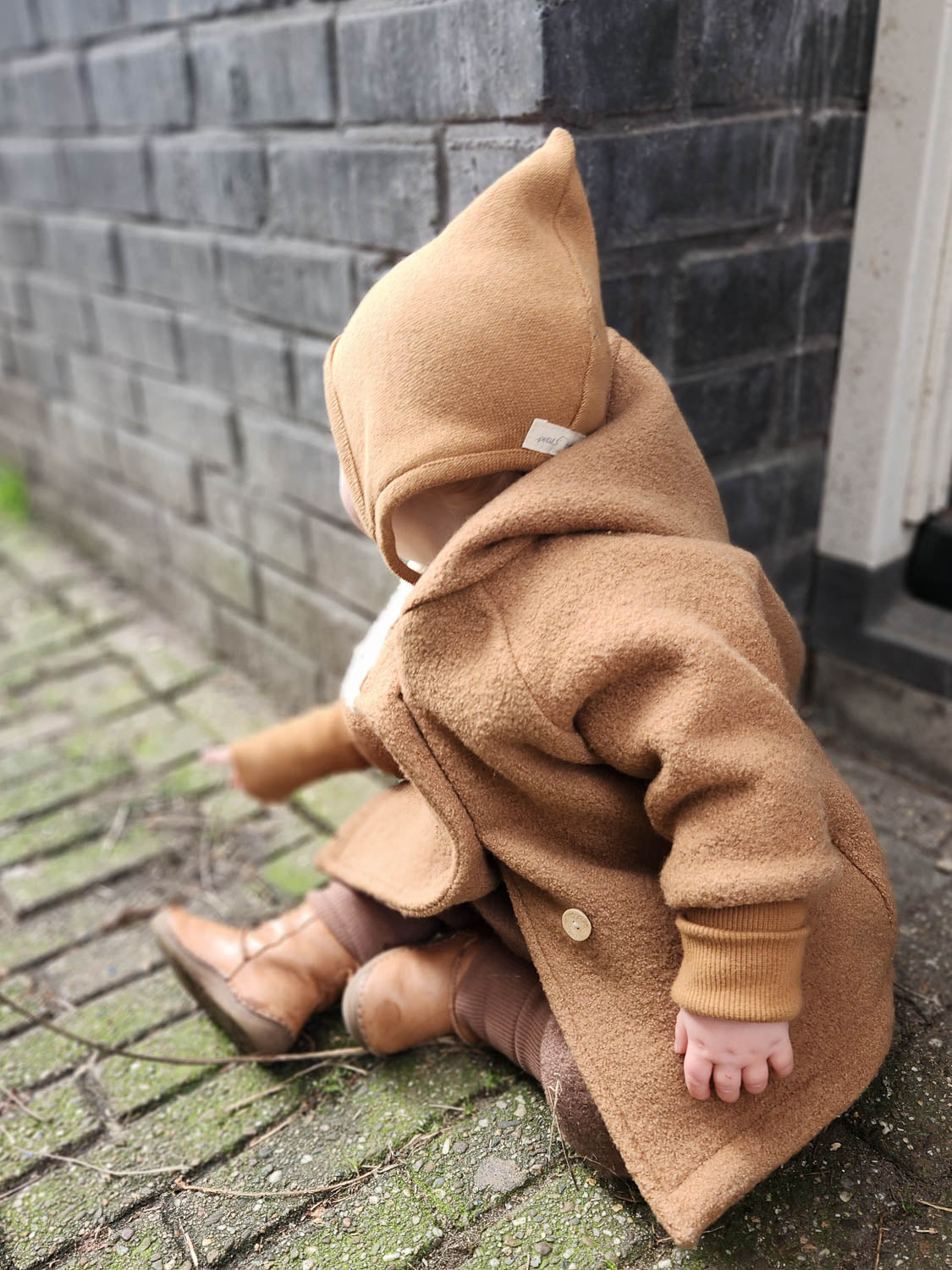 Baby trägt Zwergenmütze Strick - Sahara, gestrickt aus recycelter Baumwolle mit Bindeband, perfekt für die kühleren Monate.
Erstausstattung Babys. Perfekte Baby Geschenke.