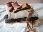 Baby Erstausstattung für ein Neugeborenes: Eine Auswahl an komfortabler Babykleidung und Accessoires, die für das erste Jahr nötig sind.