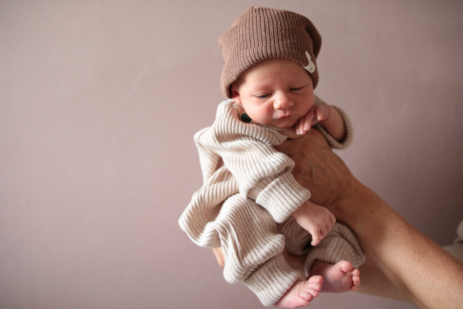 Erstausstattung für Babys, der Baby Strampler aus Rippstrick und eine Beanie von Petit Cochon.