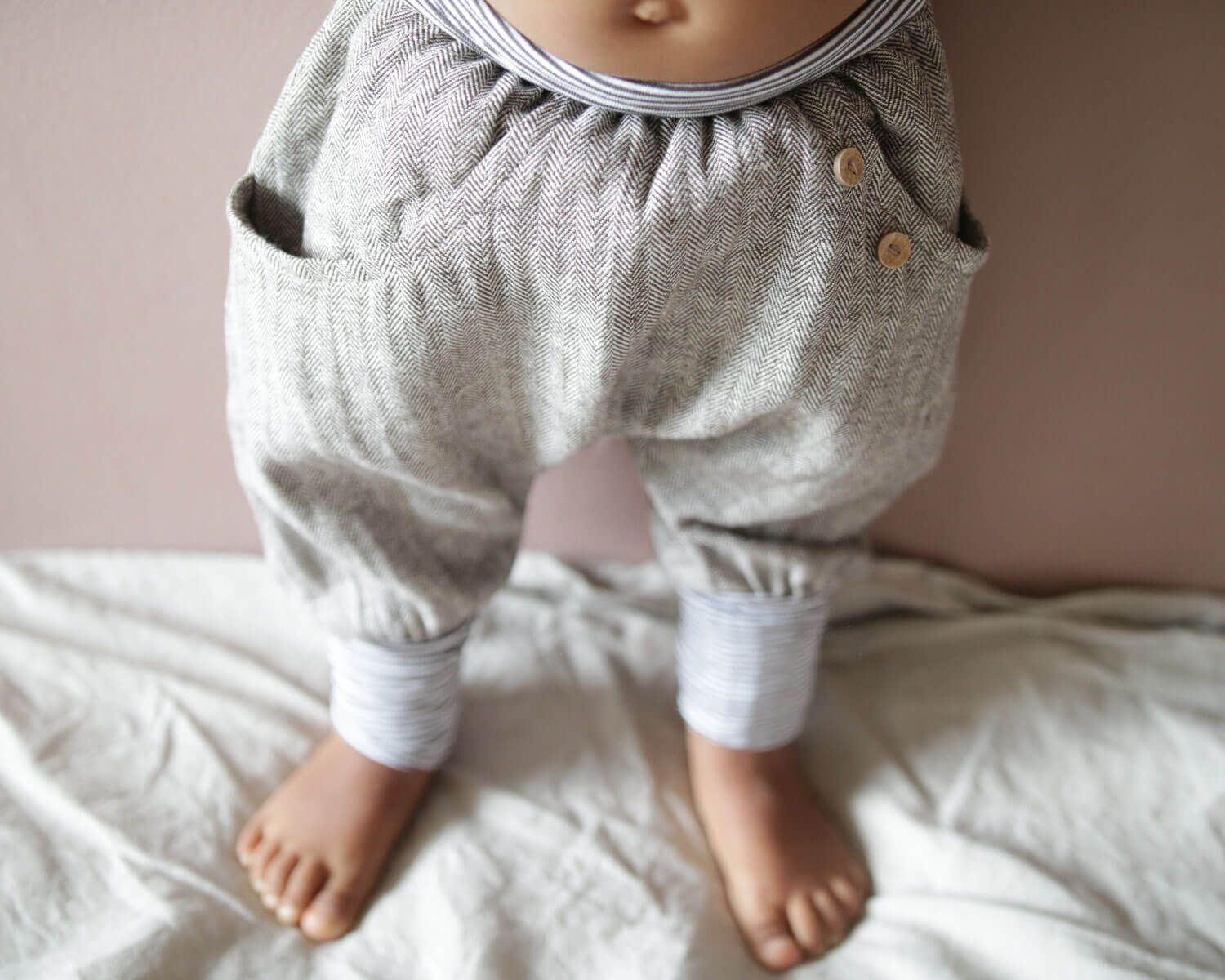Nahaufnahme von Babybeinen in Hose für Kleinkind aus Fischgrat , bequeme Hose für Kinder, genäht in Deutschland.