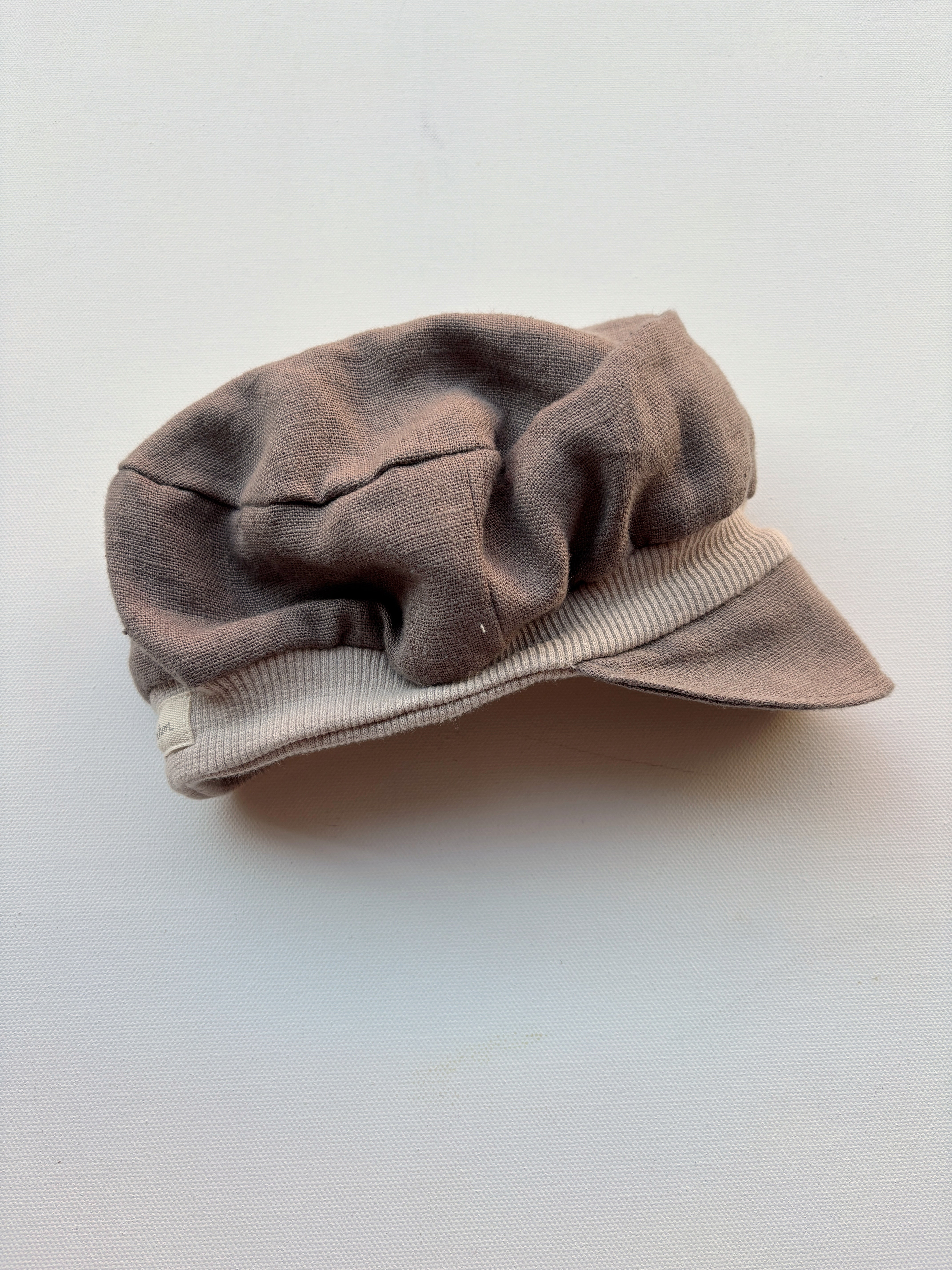 Michelmütze Leinen Praline Gr. 6M auf weißer Fläche, Nahaufnahme eines braunen Hutes mit weißem Streifen, modisches Accessoire aus Leinen, ideal für Neugeborene, neu.