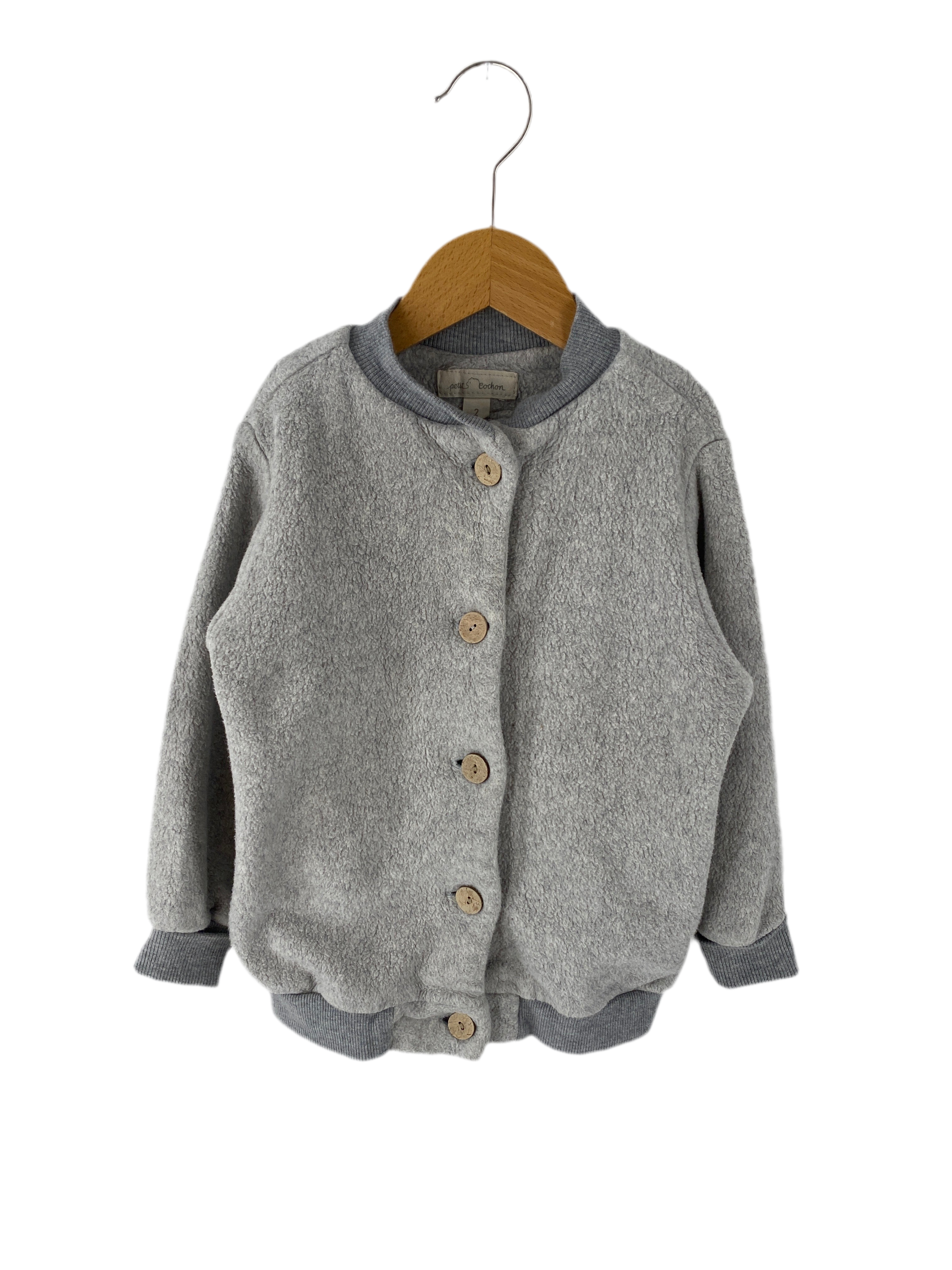 Kopie Bomberjacke Bio Plüsch Maus Gr 2Y: Eine langärmelige Kinderjacke aus weichem, fleeceartigem Material mit Holzknöpfen, gerippten Bündchen und Saum, präsentiert auf einem Holzkleiderbügel. Zustand: sehr gut.