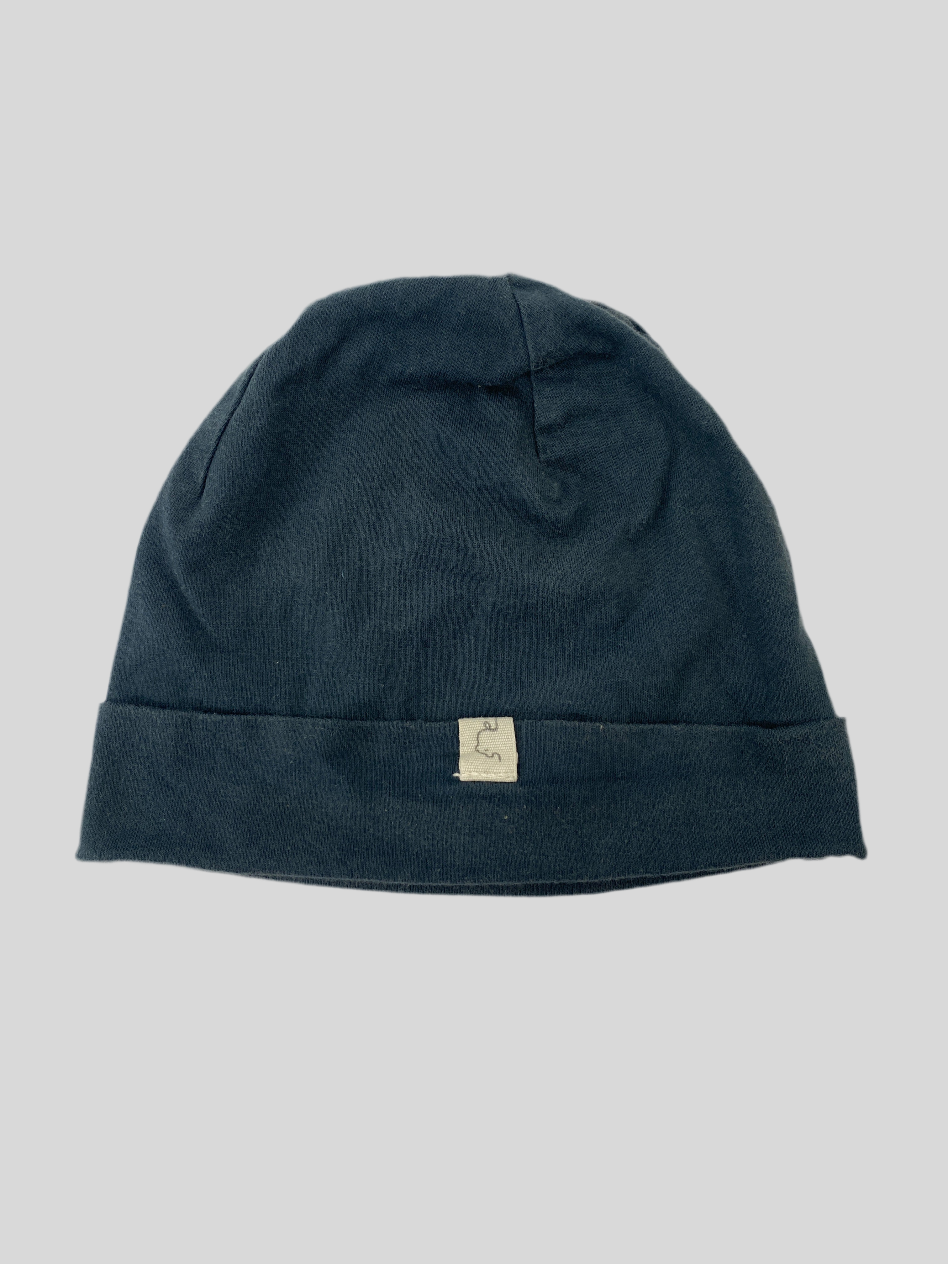 Kopie Beanie Bio-Jersey Marine Gr 6M, einfache Strickmütze im Cuff-Stil mit kleinem Rechtecketikett und minimalem Logo auf dem Umschlag, flach auf hellem Hintergrund liegend, Zustand: sehr gut.
