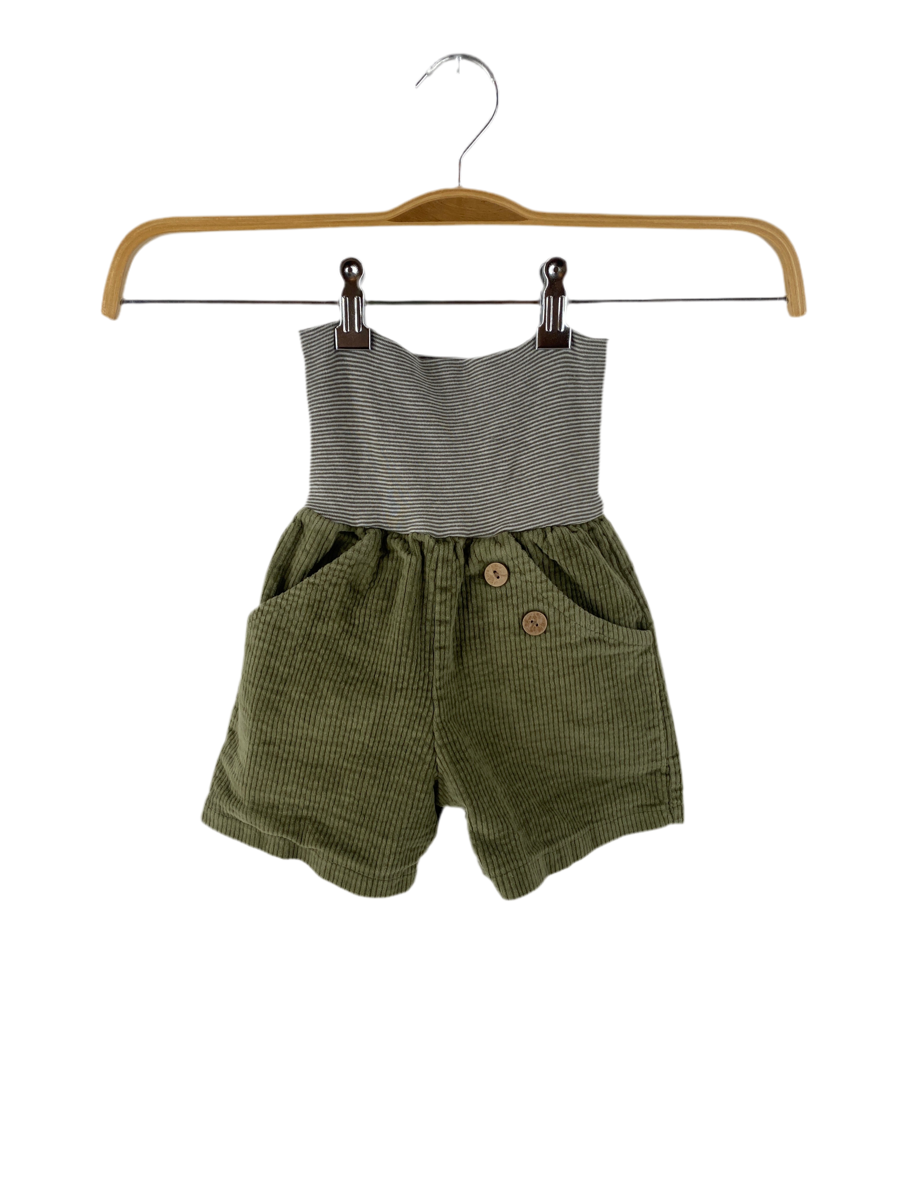 (Kopie) Kurze Buxe Breitcord Kiwi Gr 2/3Y: Ein Baby- oder Kleinkind-Einteiler mit grau-weiß gestreiftem Strickbund und olivgrüner Cordhose mit zwei Fronttaschen und Holzknöpfen an einem Bein. Zustand: sehr gut.