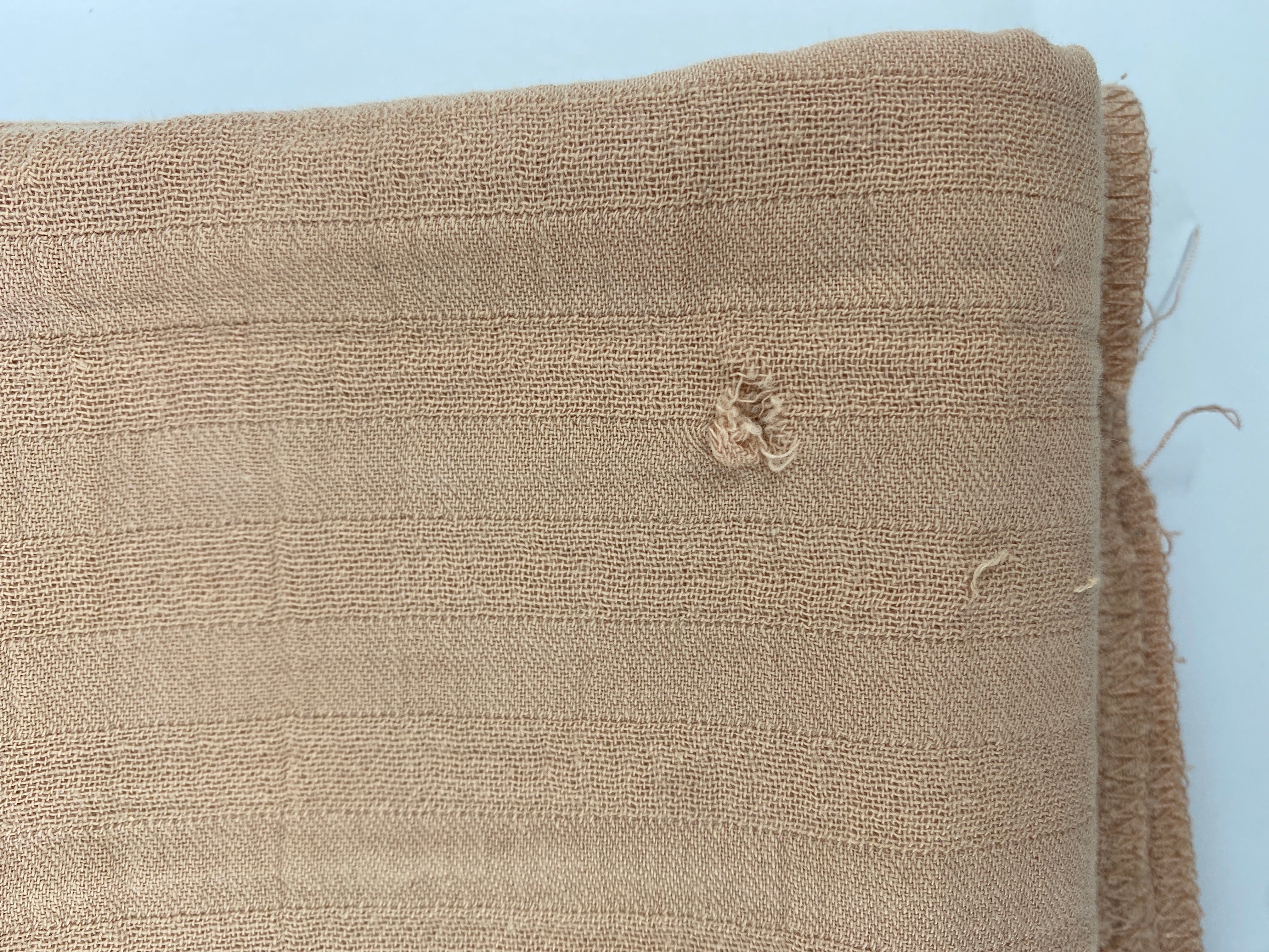 Nahaufnahme des Tuch Musselin Puder mit sichtbaren Stoffdetails. Der Zustand ist in Ordnung, trotz eines Lochs, Verfärbungen und kleiner Flecken. Struktur und Nähte sind erkennbar.