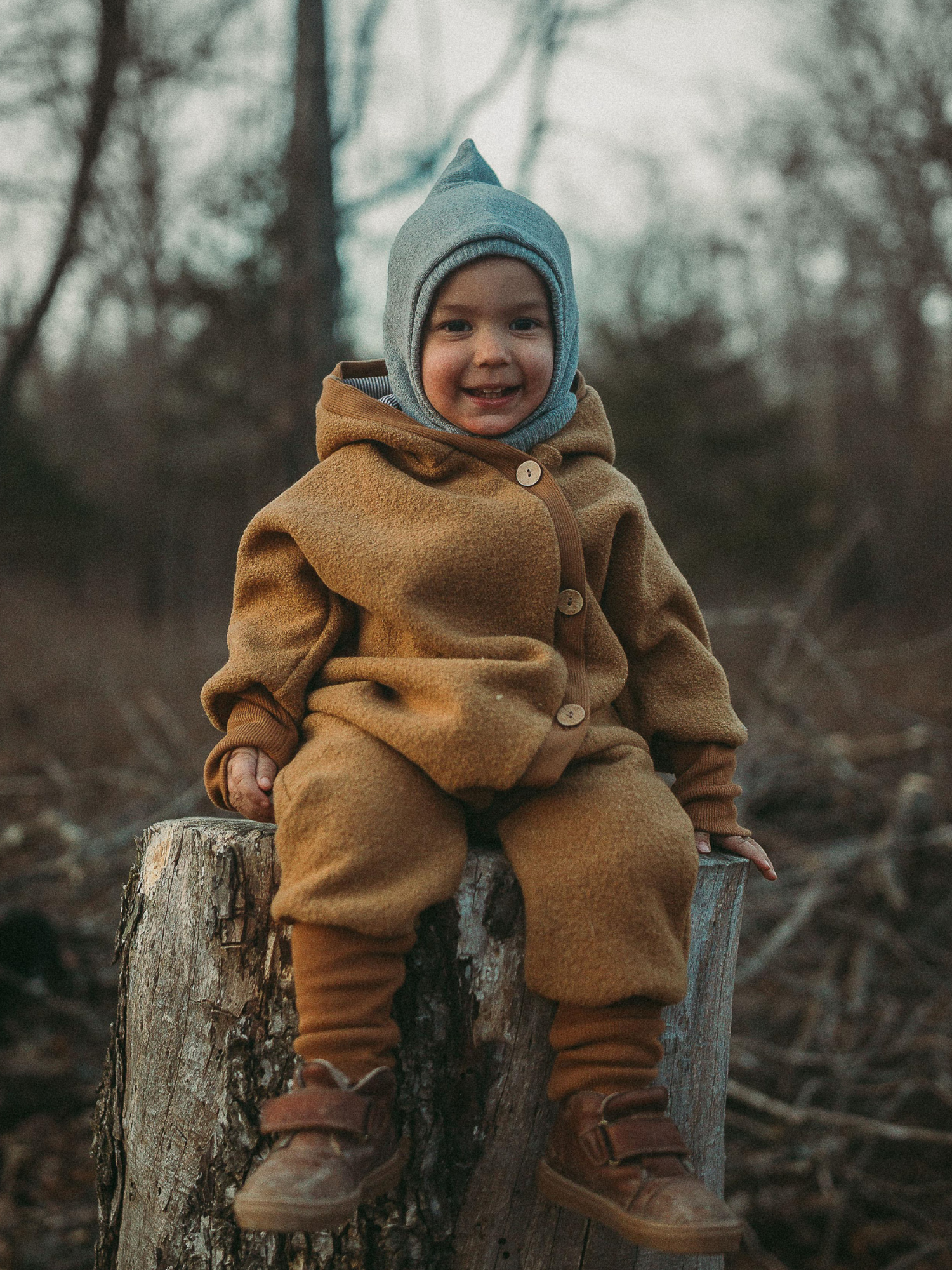 Ein Kleinkind trägt eine Schlupfmütze Strick - Maus aus weichem, elastischem Material, das den Kopf gut umschließt. Die Mütze schützt vor Wind und Kälte im Wald.