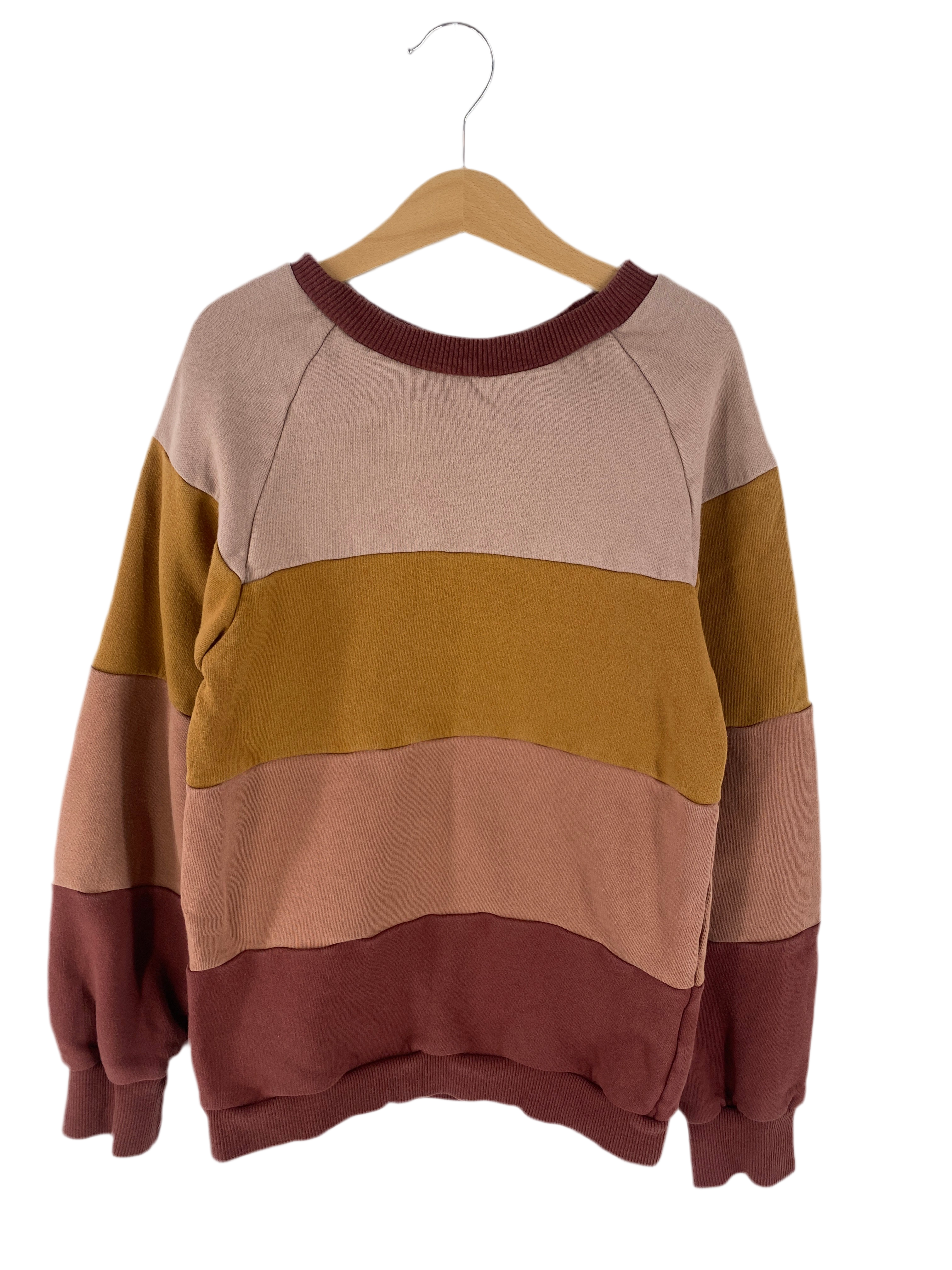 Streifenpulli Bio Sweat Puder/Zimt Gr 8/9: Langarm-Sweatshirt mit Rundhalsausschnitt, breite horizontale Farbblöcke in Erdtönen. Bündchen in Zimtbraun, auf Holzkleiderbügel präsentiert. Zustand: gut.
