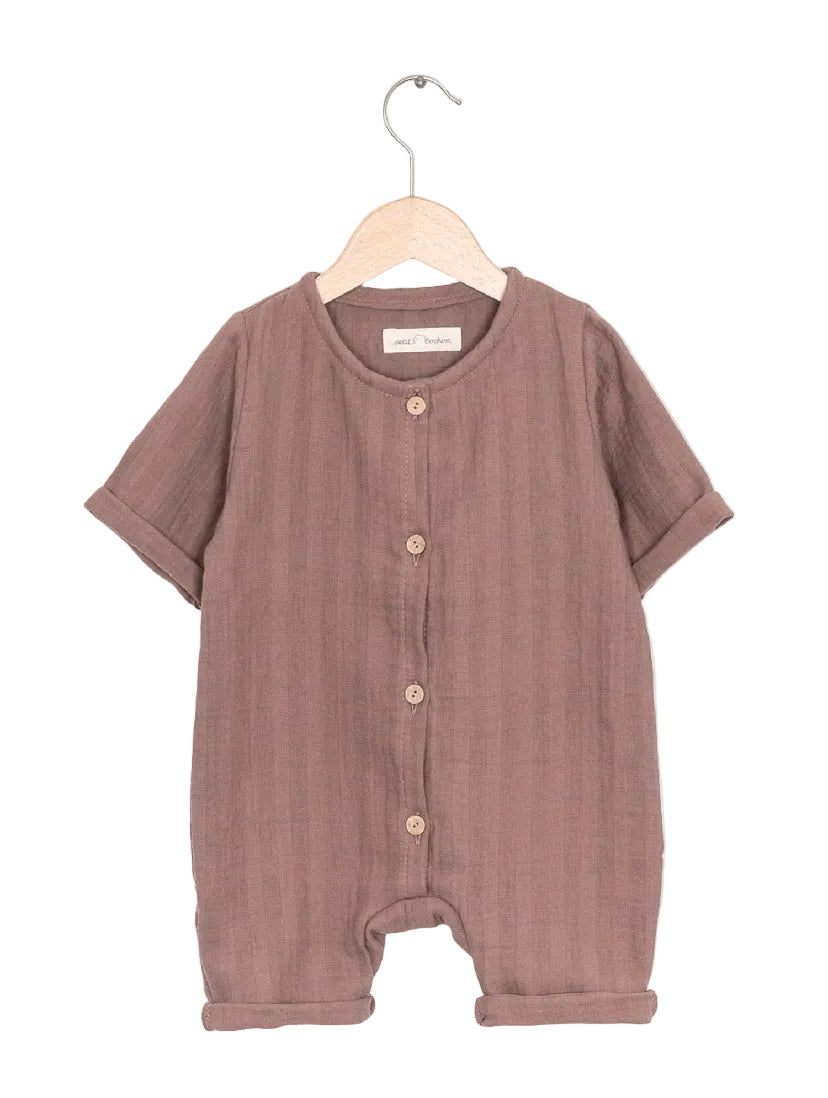 Der Kopie Mini Overall Musselin Puder Gr 0M zeigt einen kurzärmeligen Baby-Overall mit Knopfleiste, aus weichem Baumwoll-Musselin, auf einem schlichten Holzbügel aufgehängt.