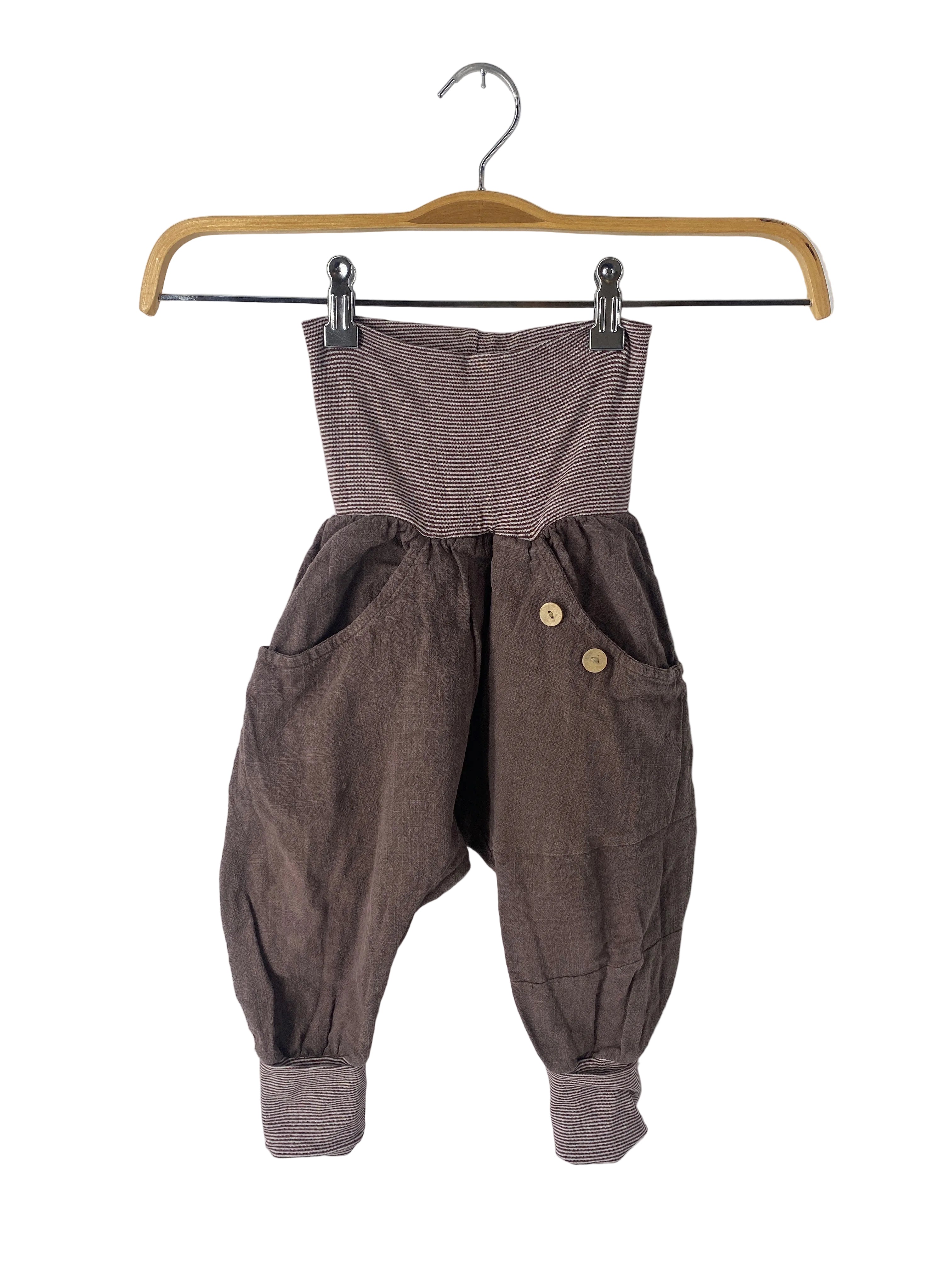 Knickerbocker Leinen Erde Gr 3Y: Kinderharemshose mit weichem, dunkelbraunem Stoff, elastischem Streifenbund, tiefen Seitentaschen, Holzknöpfen und ballonförmigen Beinen. Ideal für Komfort und Bewegungsfreiheit. Zustand: gut, Flicken eingenäht.
