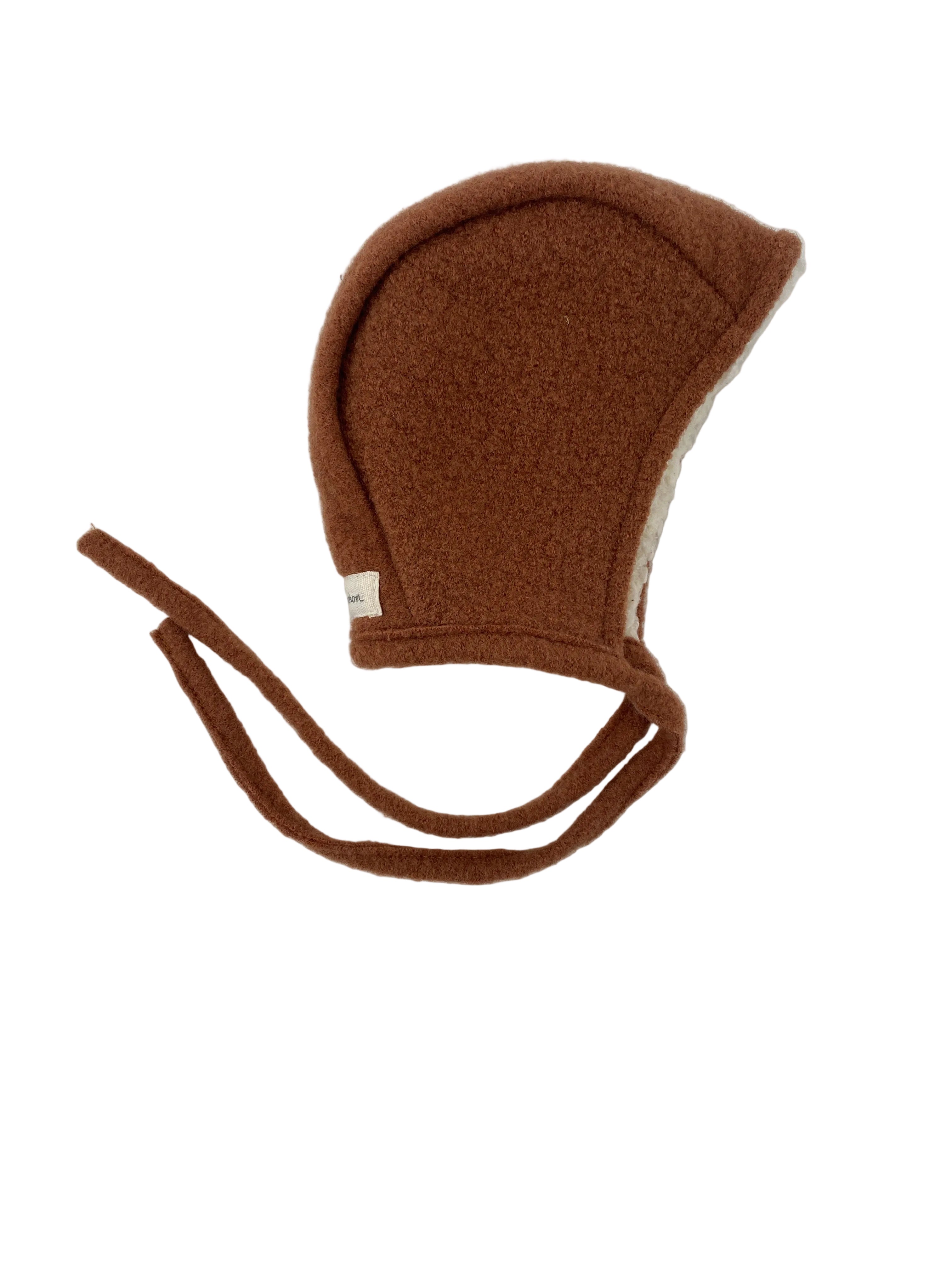 Babymütze Wollwalk Sahara mit Teddyfutter Gr 6M, eine kleine braune Fleecehaube mit Ohrklappen und langen Bindebändern, innen gefüttert mit weichem, off-white Sherpa-Material. Zustand: sehr gut, wie neu.