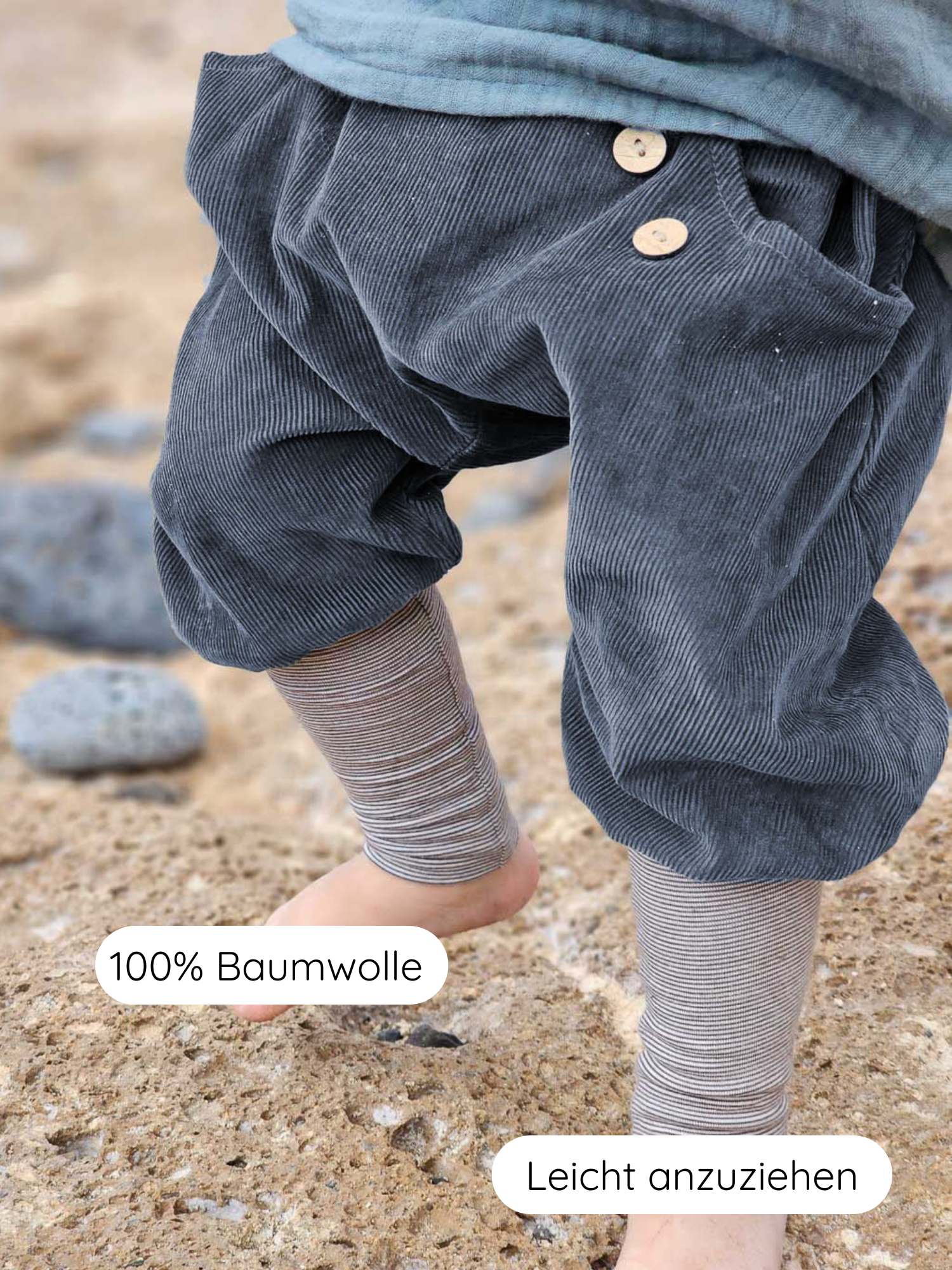 Knickerbocker Feincord Ringel - Blaubeere: Kind steht auf Sand, trägt dunkle Cord-Knickerbocker mit Holzknöpfen, gestreifte Leggings sichtbar am Knöchel. 100% Baumwolle, leicht anzuziehen.