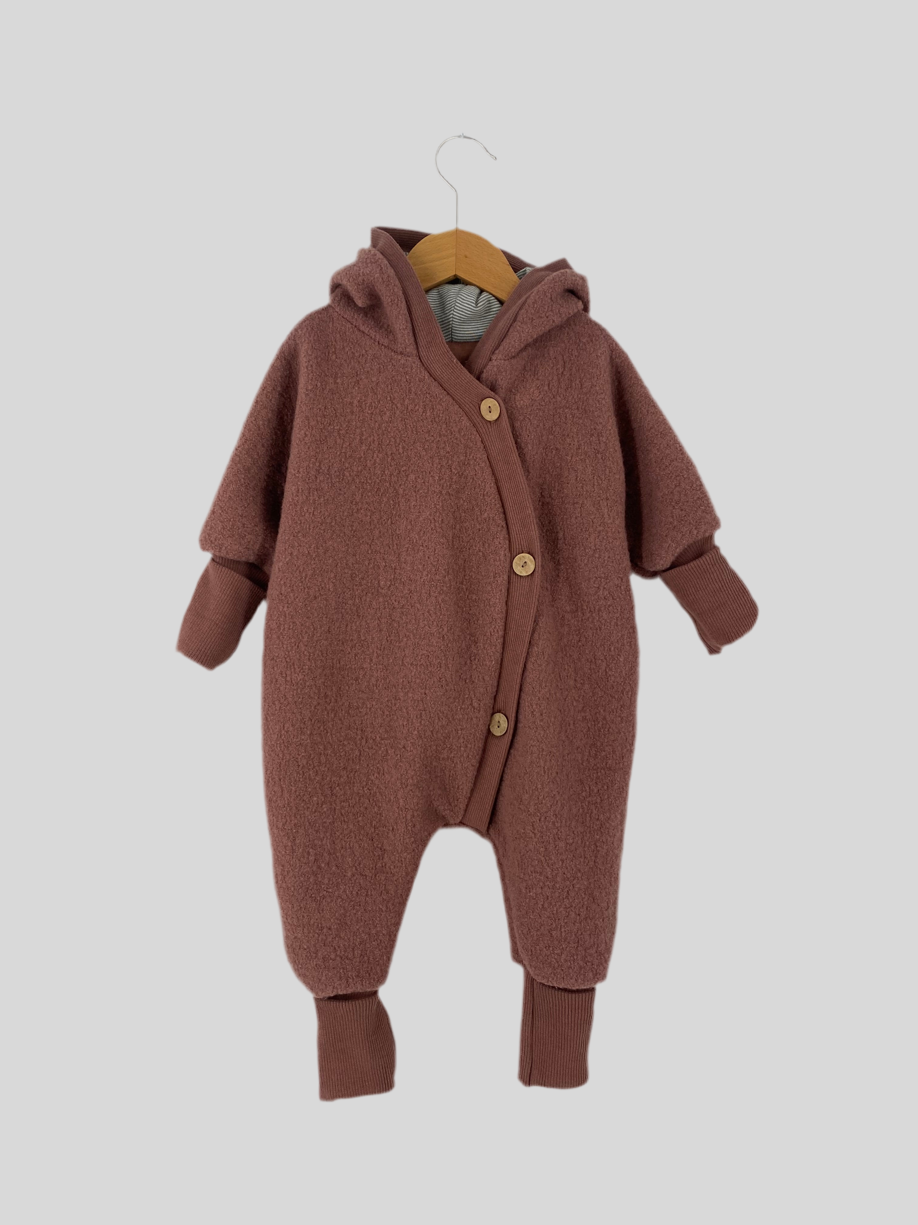 Kuschelanzug Wollwalk Zimt Gr. 3M, Zustand: wie neu, zeigt einen weichen, strukturierten Wollanzug. Ideal für Babys, bietet er Komfort und Wärme. Perfekt verarbeitet mit liebevollen Details für Neugeborene.