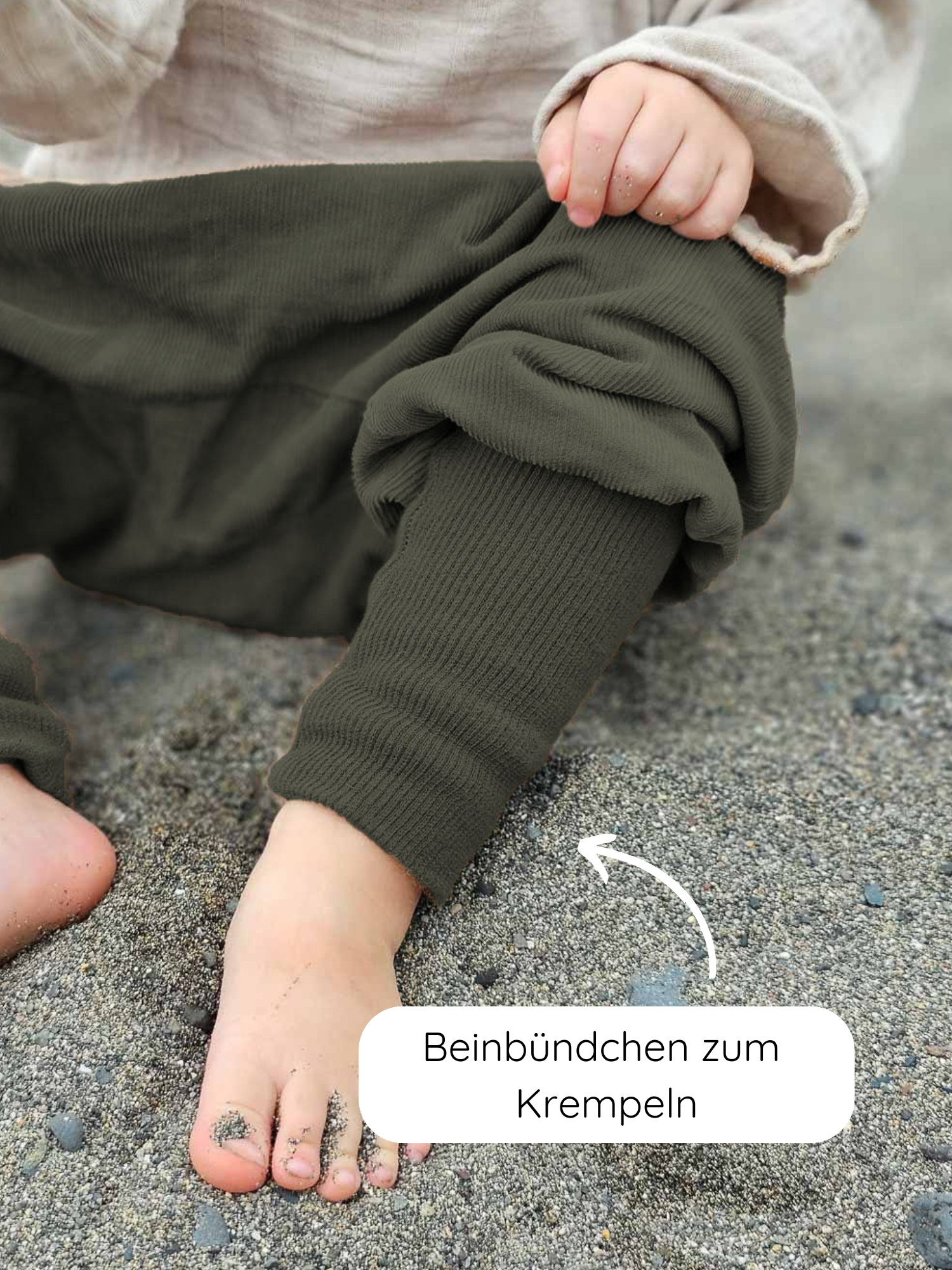 Nahaufnahme eines Kinderbeins in olivegrünen Knickerbocker Feincord - Avocado mit krempelbarem Beinbündchen. Die Hose ist aus weichem Cord, ideal für aktive Kinder, mit elastischem Bund.
