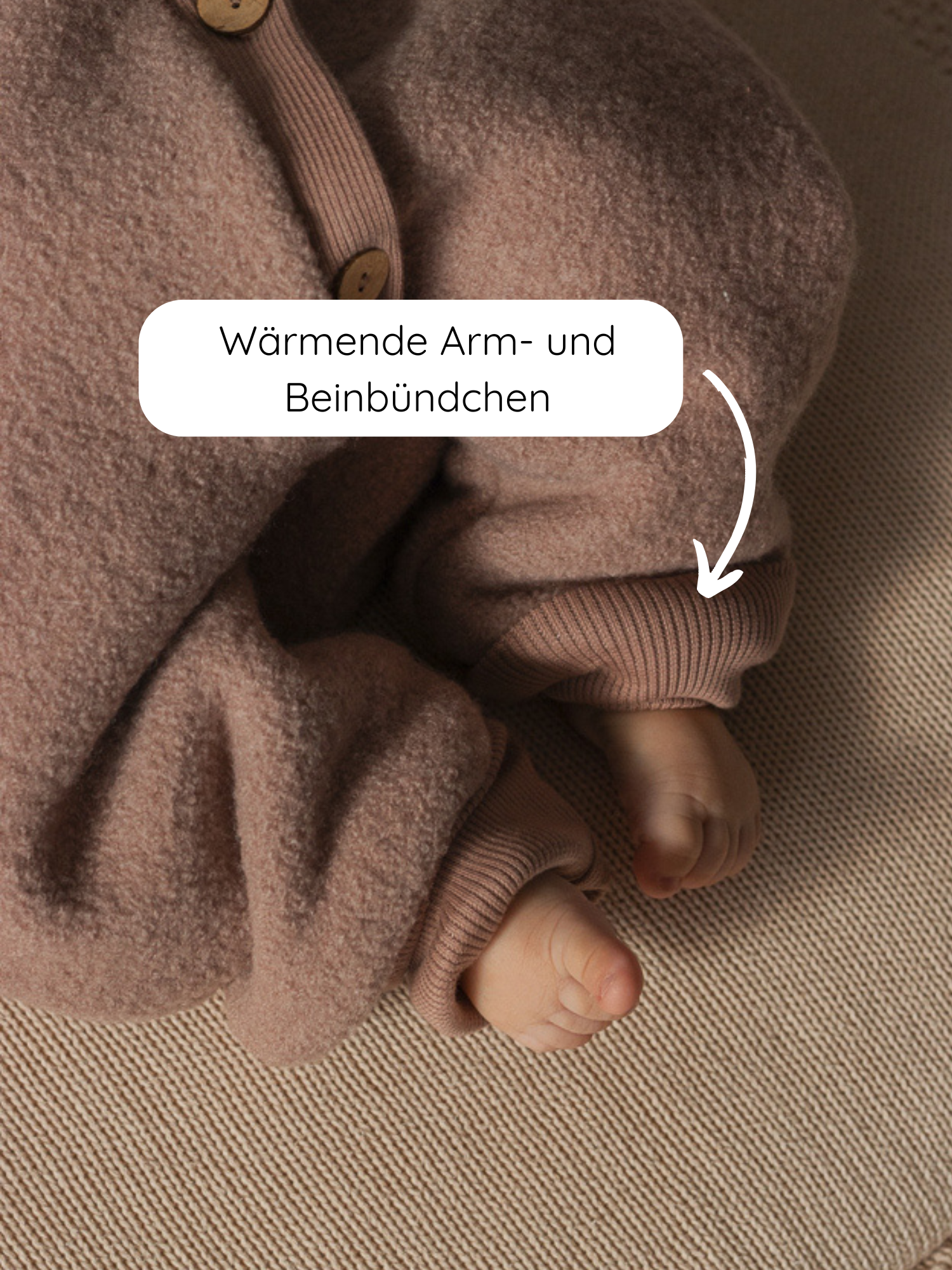 Baby trägt Winter Wollwalk Overall mit Teddyfutter- Puder; Nahaufnahme zeigt weiche, beige Fleece-Einteiler mit elastischen Bündchen an Armen und Beinen, betont wärmende Arm- und Beinbündchen, nackte Füße sichtbar.