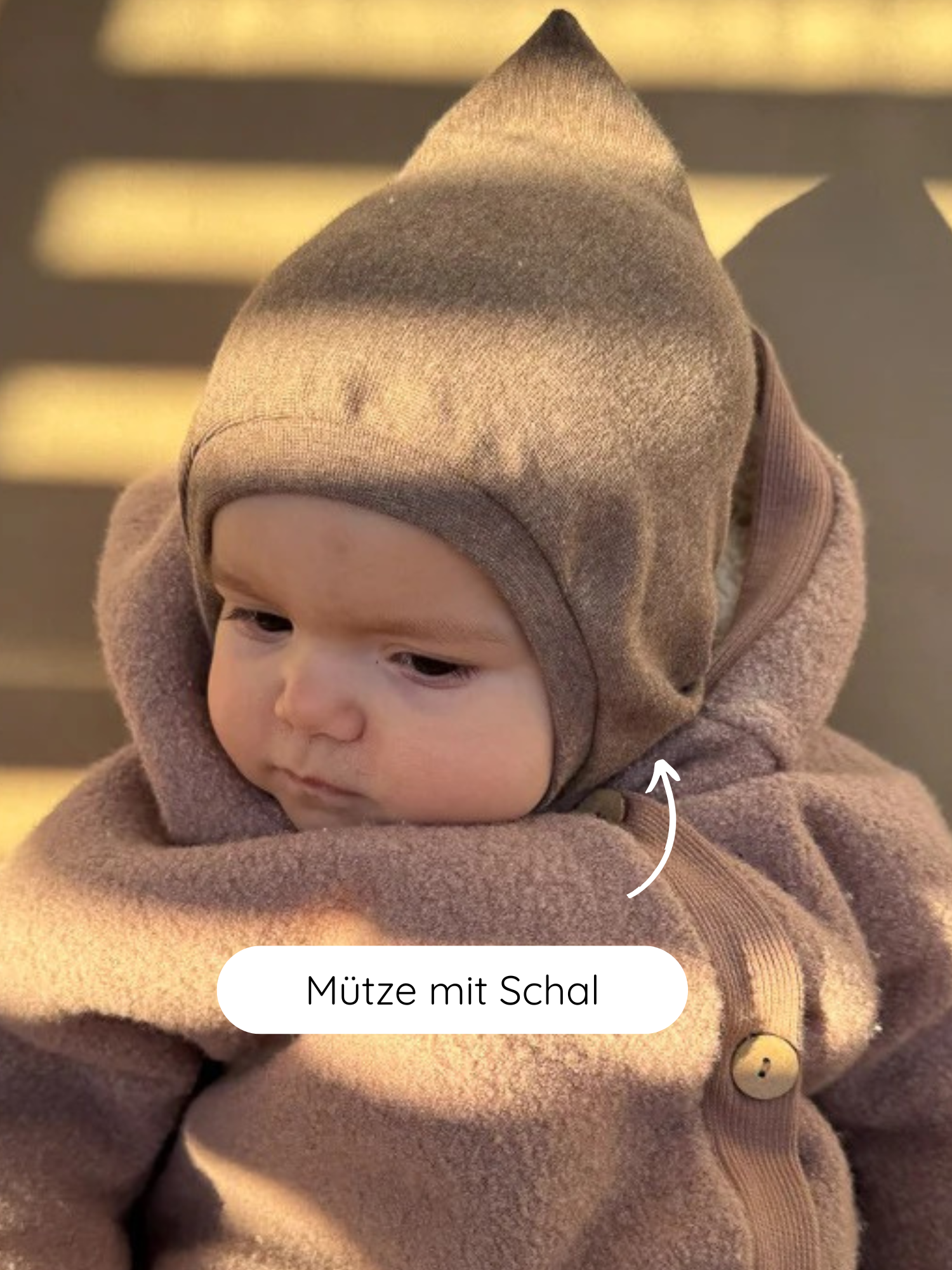 Kleinkind mit der Schlupfmütze Feinstrick - Hafer Meliert, die Kopf und Hals schützt. Die Mütze aus meliertem Feinstrick-Jersey ist weich und formstabil, mit integriertem Schal, ideal für kühle Tage.