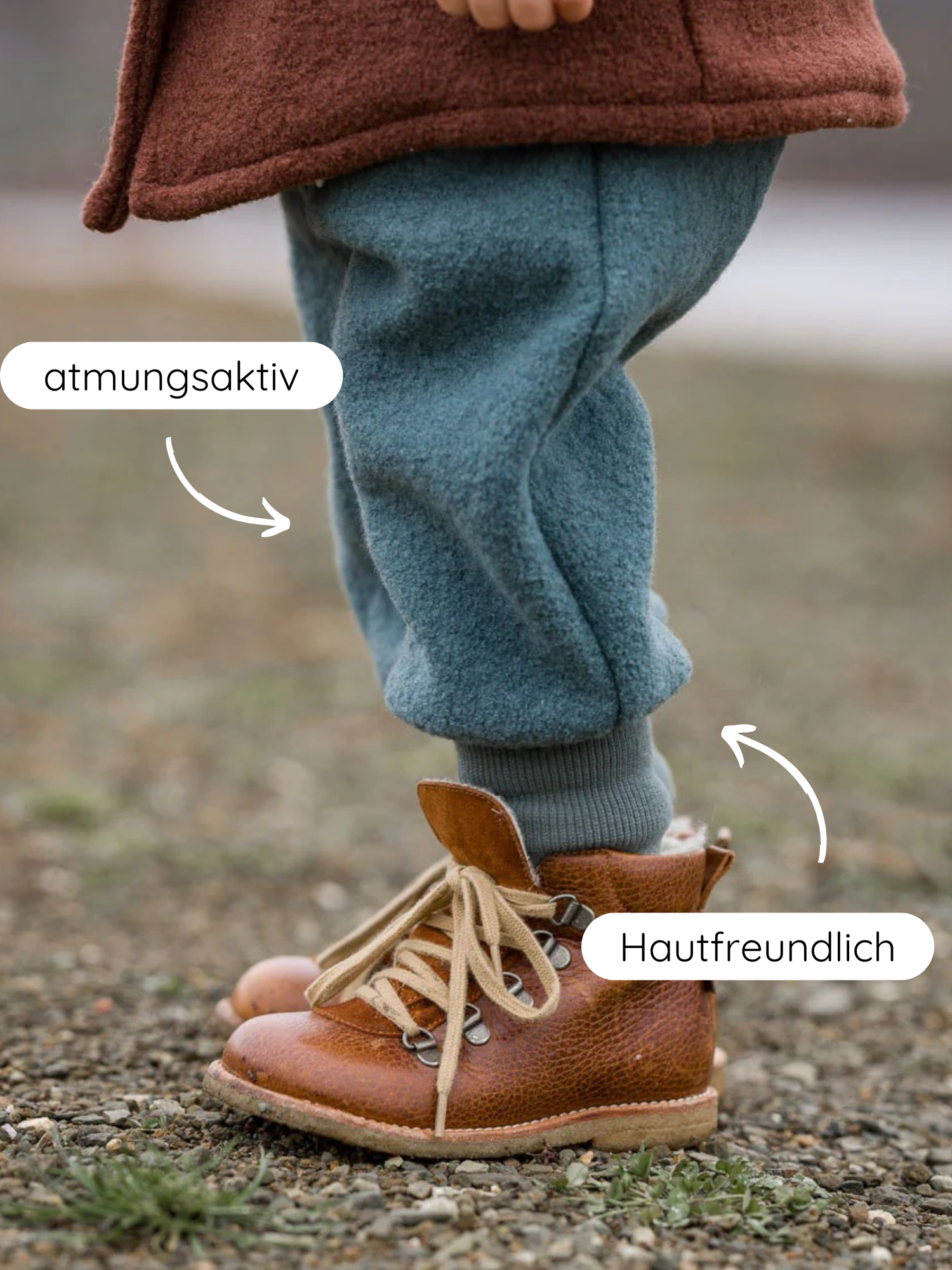 Nahaufnahme eines Kindesbeins in atmungsaktiven, weichen, teal farbenen Knickerbocker Wollwalk - Taube Hosen und hautfreundlichen Socken in braunen Lederstiefeln auf Kiesuntergrund, betont Komfort und Materialqualität.