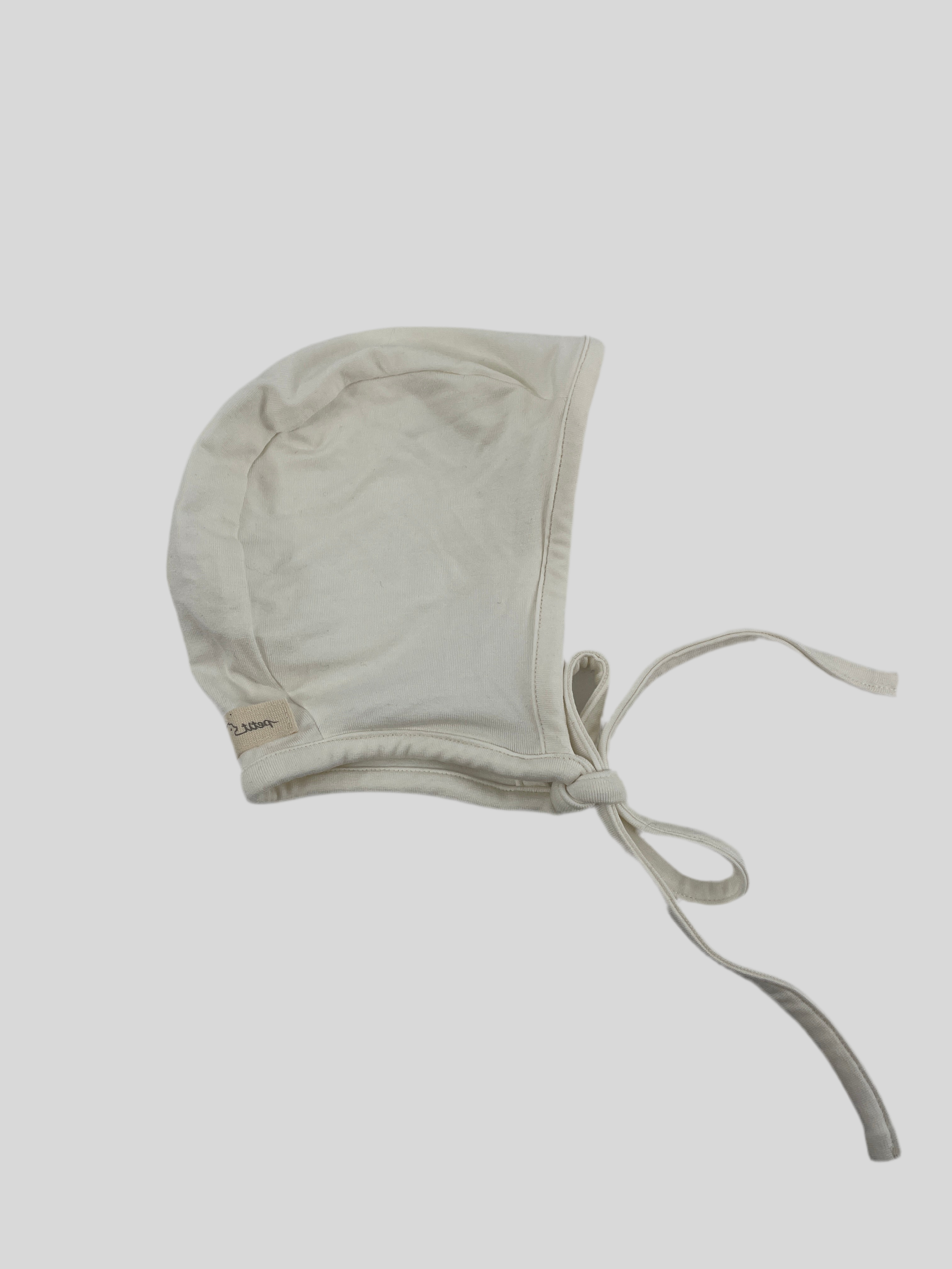 Babyhäubchen Jersey Natur Gr. 6M mit kleinem Loch auf der linken Seite, zeigt ein schlichtes Design, ideal für Babys im Alter von sechs Monaten. Zustand: neu.