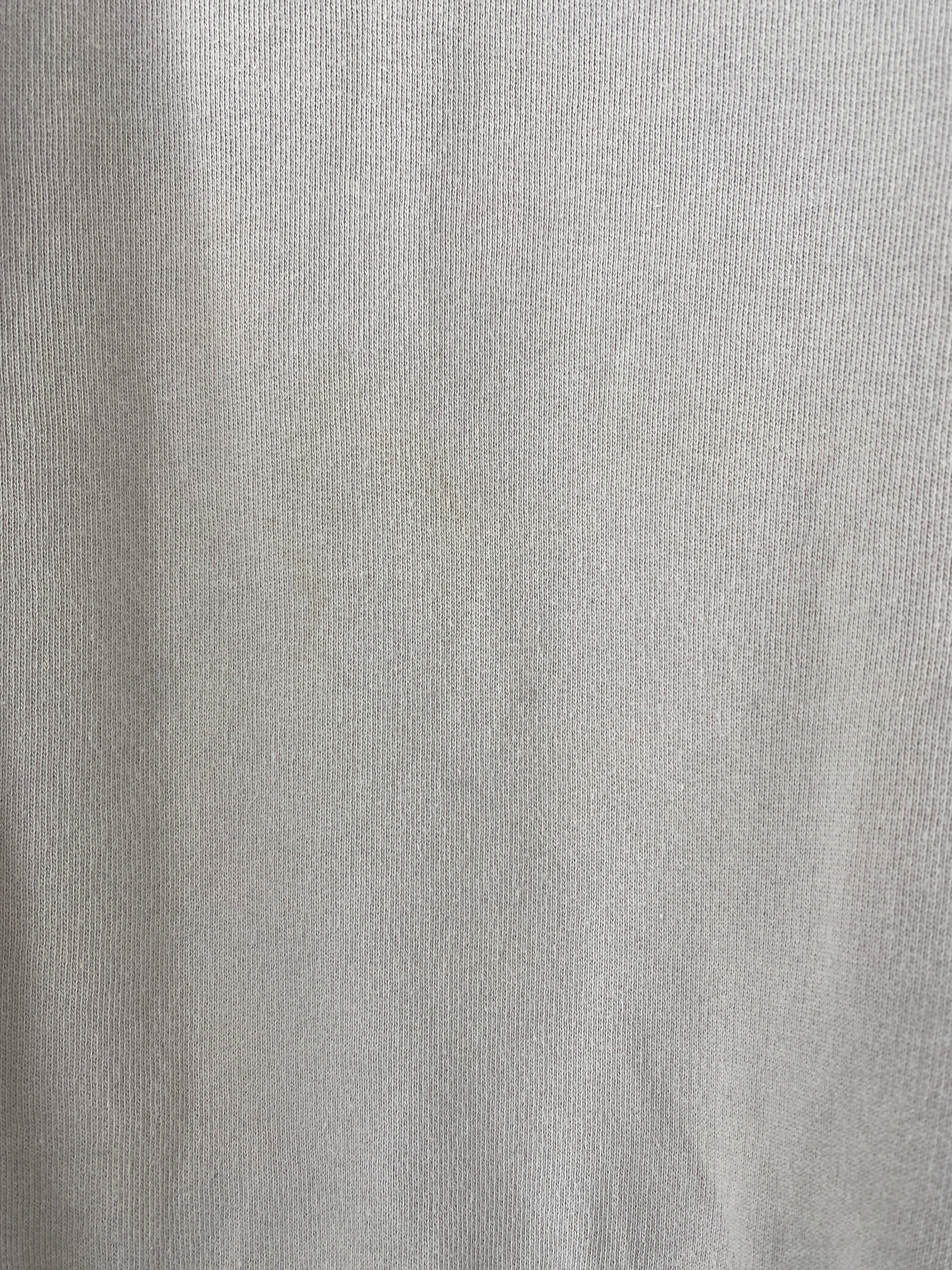 Nahaufnahme des Frauen Pulli kurz Bio Sweat Sand Gr S, aus leichtem Jersey-Strickstoff. Ein schwacher, gelblicher Fleck ist nahe der Mitte sichtbar, Zustand gut mit leichter Verfärbung.