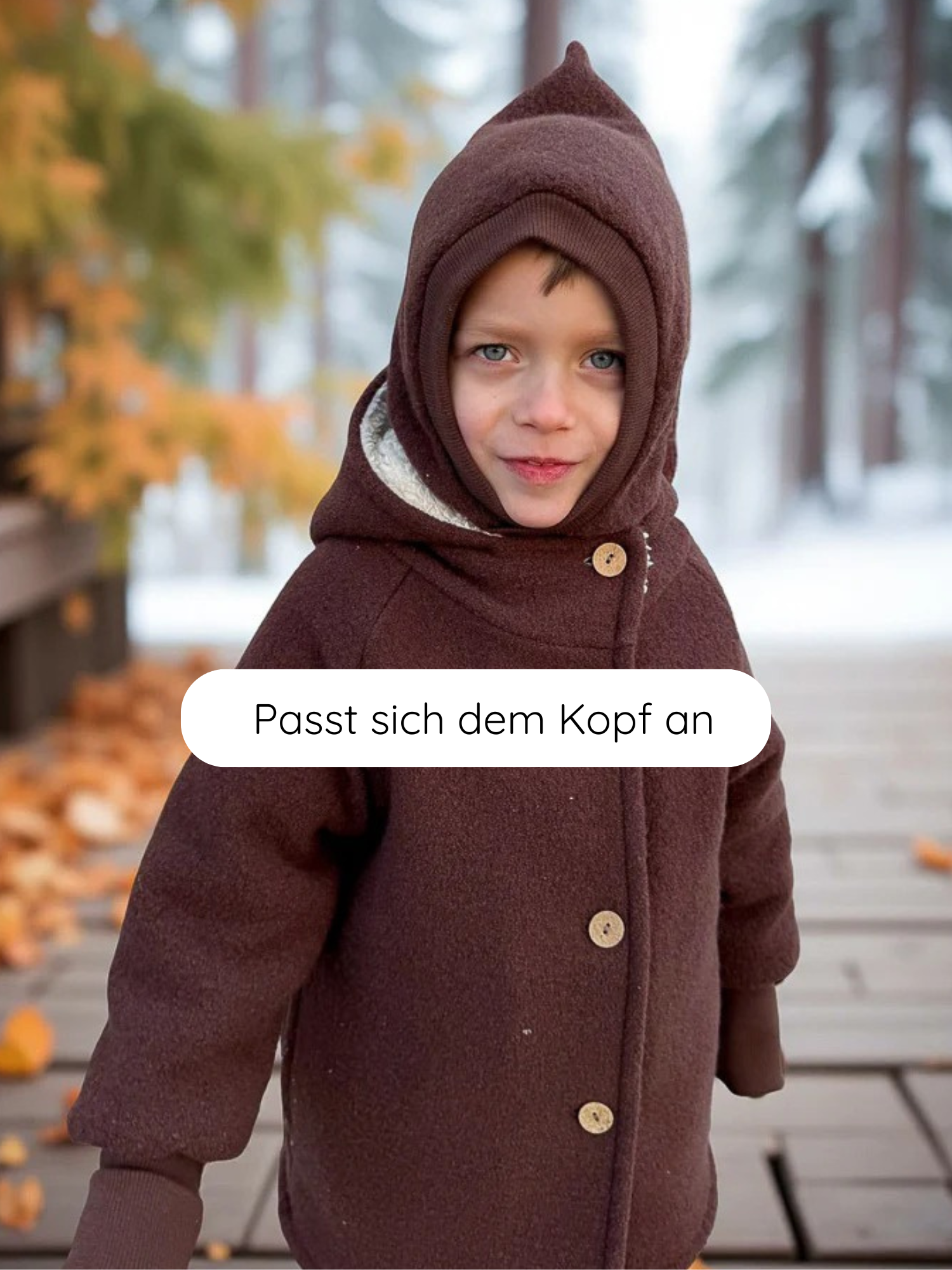 Kind trägt Schlupfmütze Wollwalk - Schoko mit spitzer Kapuze und passenden Fäustlingen auf Holzsteg. Die Mütze schmiegt sich perfekt an und schützt zuverlässig an kalten Tagen.