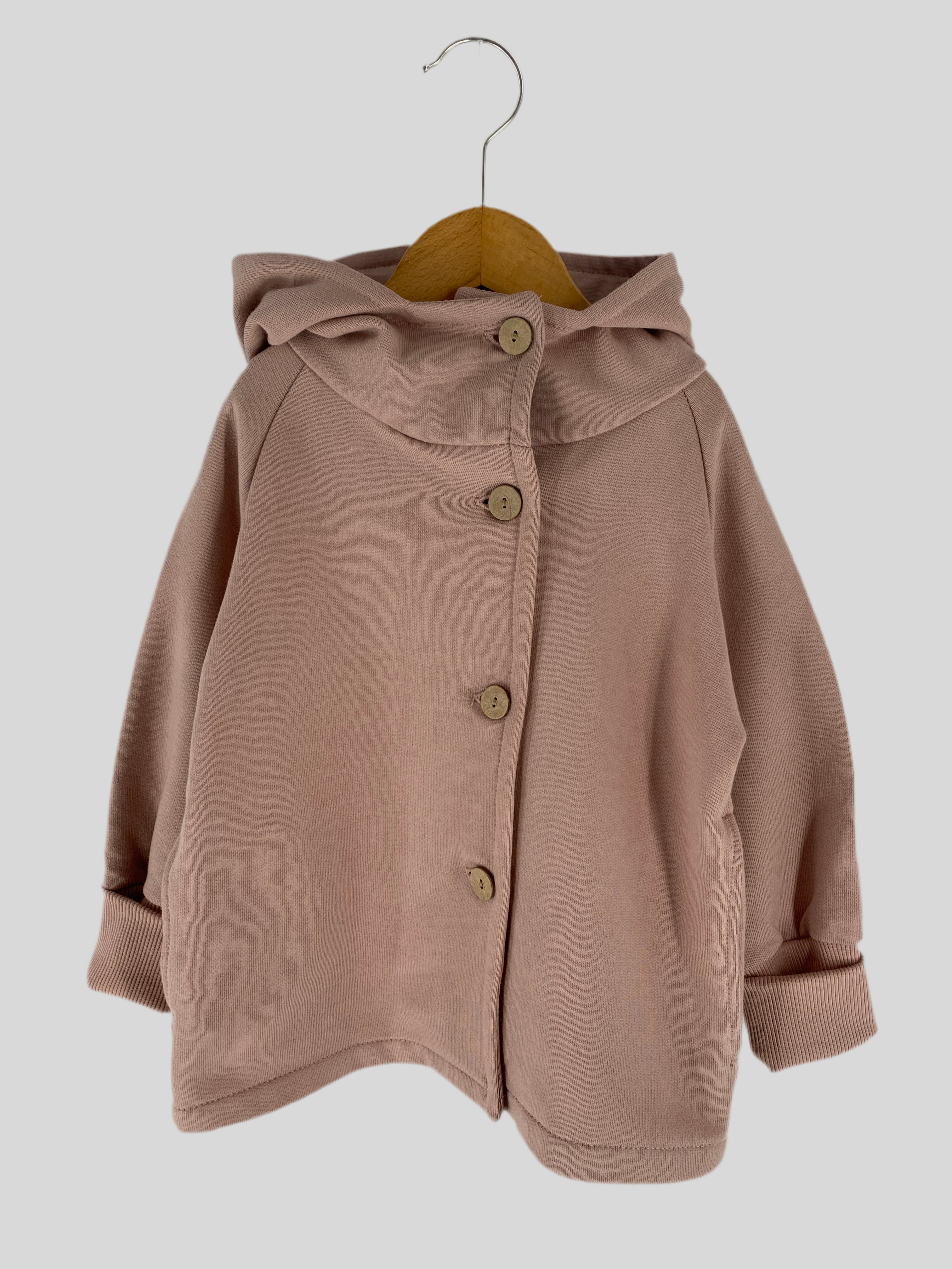 Wichteljacke aus Bio-Sweat für Kleinkinder, helles Puder, Gr 2Y. Dargestellt ist die Jacke mit Knöpfen, auf einem Kleiderbügel hängend, betont die hochwertige Verarbeitung und das modische Design. Zustand: neu.