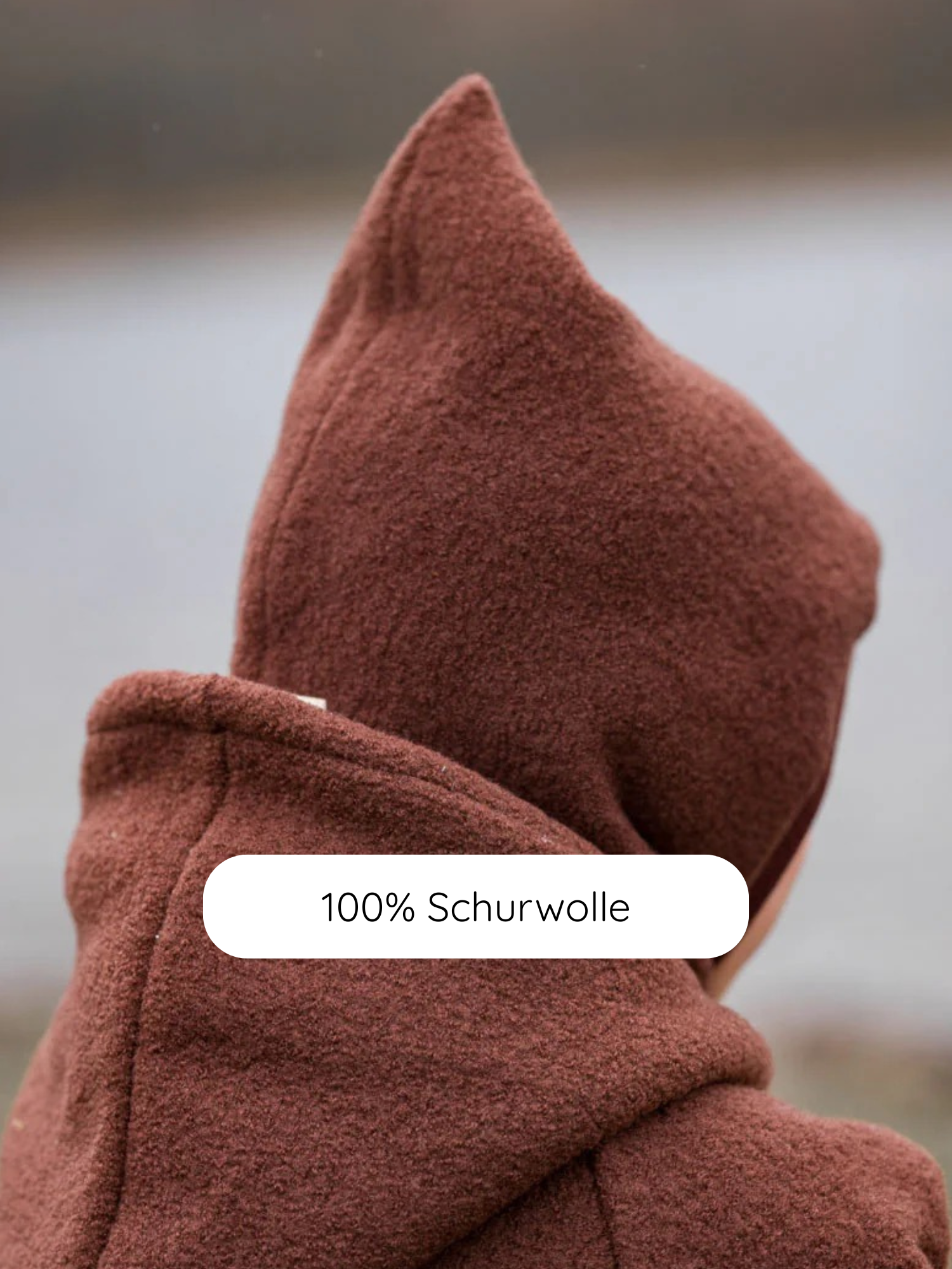 Schlupfmütze Wollwalk - Schoko: Rückansicht einer braunen Wollmütze mit spitzer Kapuze. Der Wollwalk schützt vor Kälte, während Bio-Jersey-Innenfutter für Komfort sorgt. Ideal für kalte Tage.