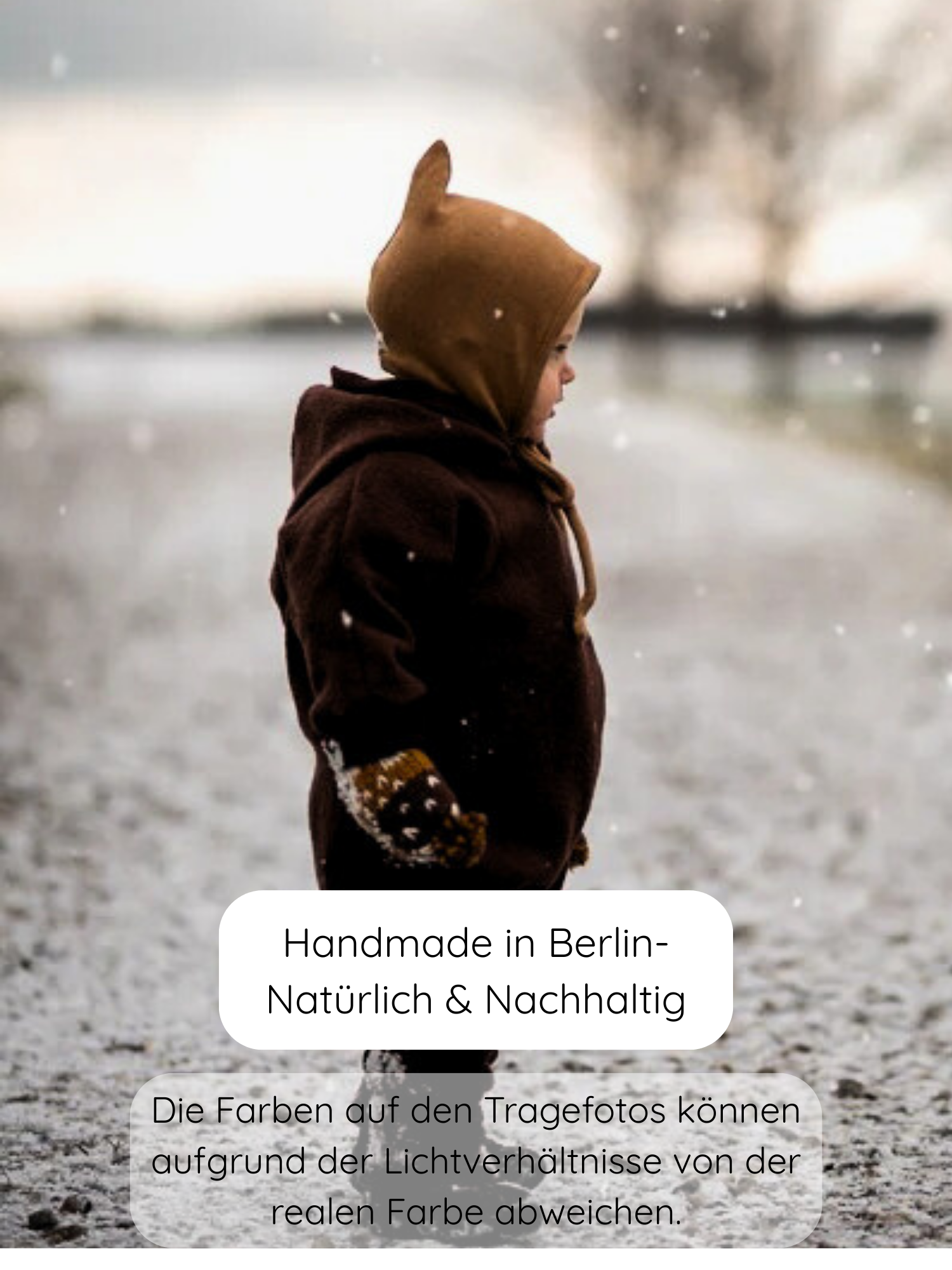 Kleinkind im Winter Wollwalk Overall mit Teddyfutter - Schoko, steht im Schnee. Der Overall hat eine Kapuze und passende Fäustlinge, ideal für kalte Tage, handgefertigt in Berlin.