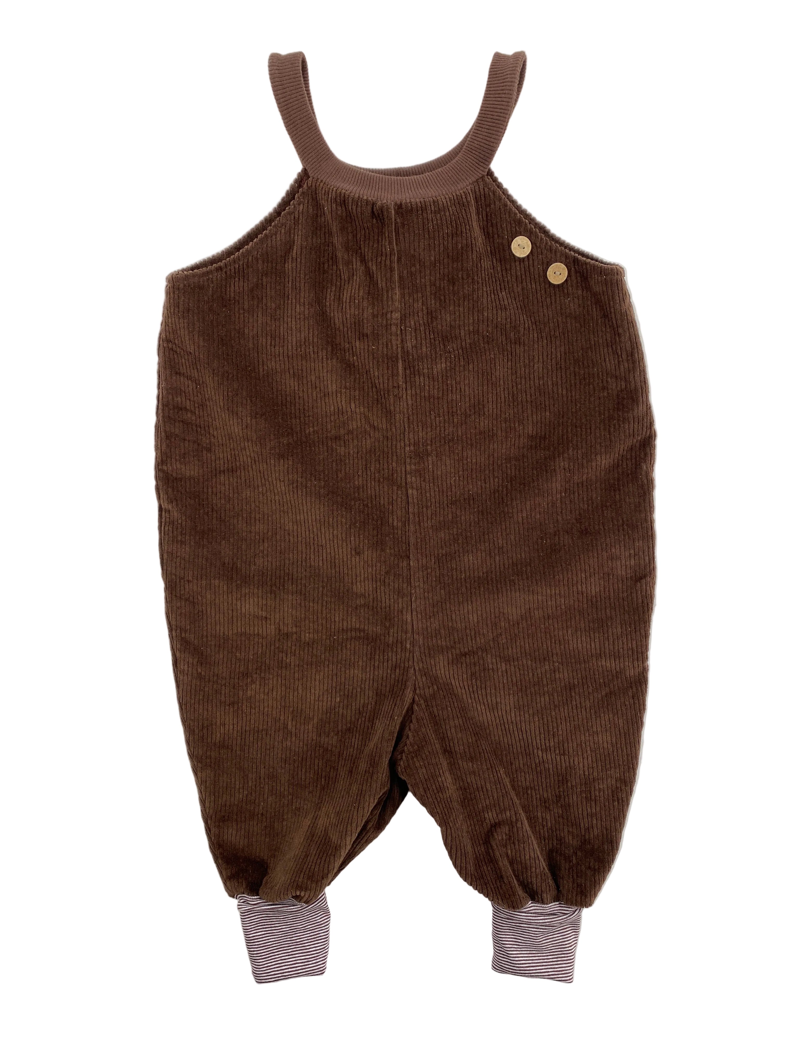 Schlupflatzhose Breitcord Schoko Gr 2Y: Einteiliger Overall aus braunem Cordstoff mit Tankträgern, zwei Holzknöpfen auf der Brust und gestreiften Rippbündchen an den Beinen. Zustand: neu.