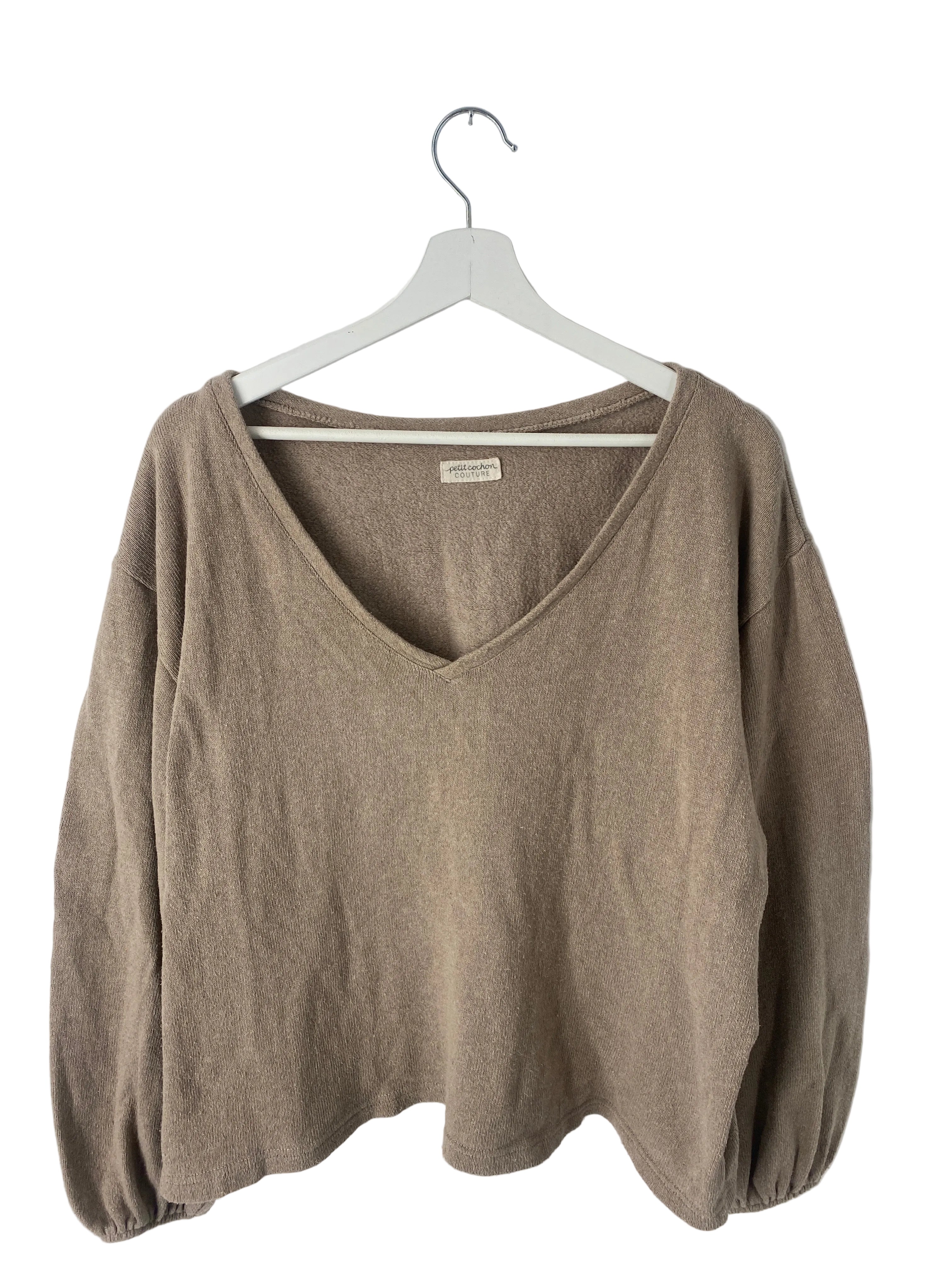 Kopie Frauen Pulli Strick Hafer Gr L: Ein langärmliges, V-Ausschnitt Strickoberteil in hellem Taupe, mit leicht gerafften Bündchen und kleinem Stoffetikett im Nacken, auf einem weißen Kleiderbügel hängend.