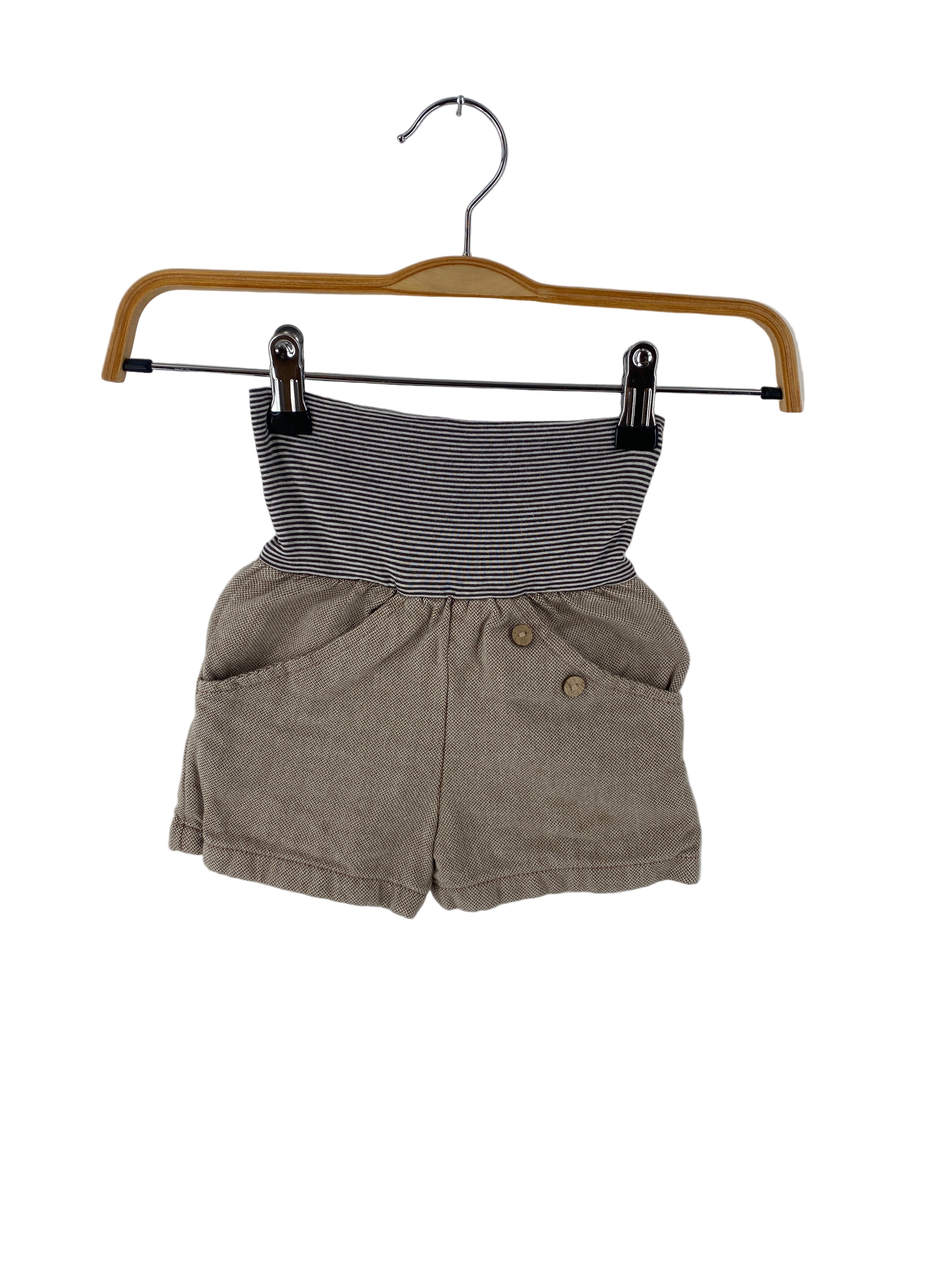 Kinder-Shorts Kopie Kurze Buxe Kreuzköper Praline Gr 2Y aus hellbraunem, strukturiertem Stoff mit zwei Fronttaschen, dekorativen Holzknöpfen und einem schwarz-weiß gestreiften, umgeschlagenen Bund. Zustand: gut.