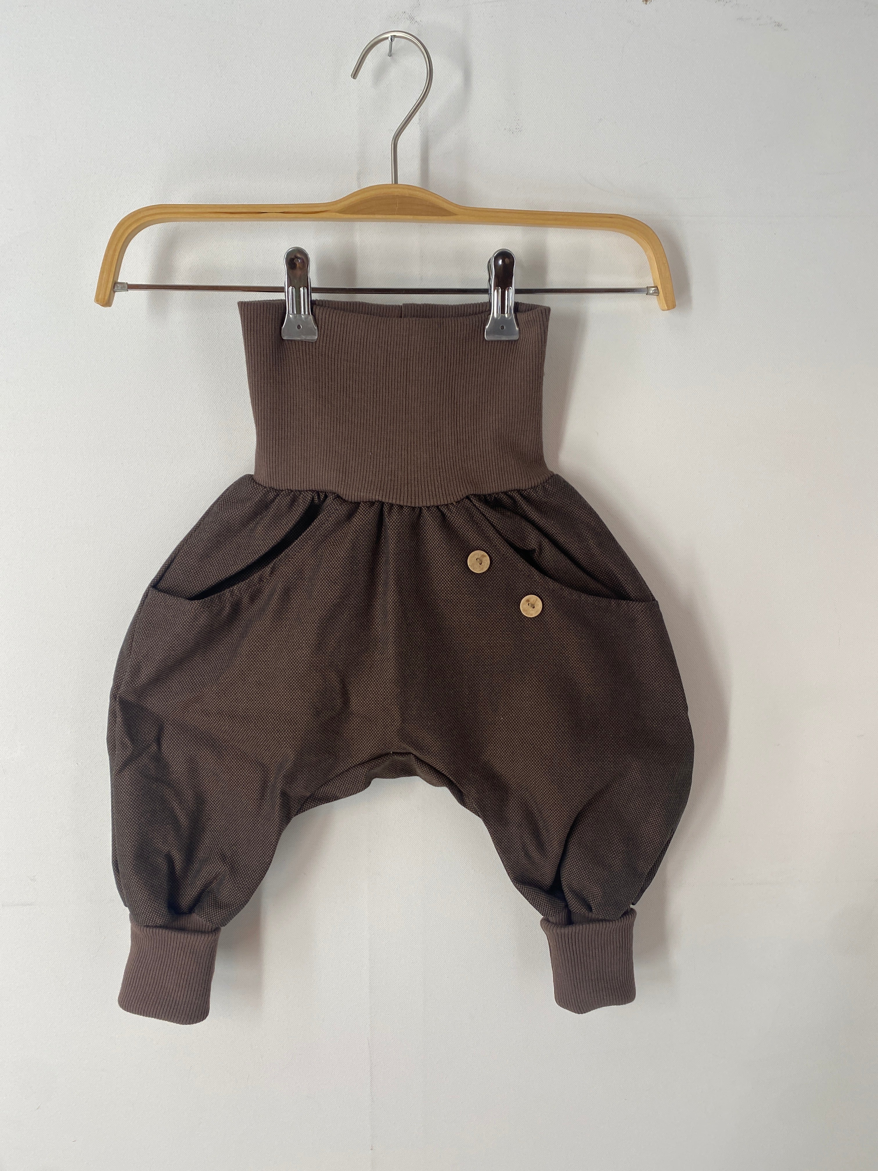 Kopie NEU Knickerbocker Bio-Kreuzköper Schoko Gr 2Y auf einem Metallbügel, mit sichtbaren Knöpfen und detailliertem Stoffmuster, präsentiert auf einem Kleiderständer.
