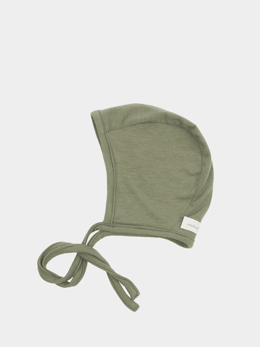 Babyhäubchen Kaschmir-Mix - Pistazie, ein weiches, olivgrünes Strickhäubchen mit langen Bindebändern aus elastischem Micromodal-Kaschmirstoff, bietet Wärme und Schutz für empfindliche Babyköpfe.