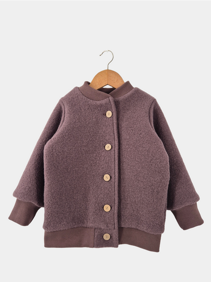 Bomberjacke Wollwalk - Malve, eine Kinderjacke aus Wollwalk mit Knöpfen, auf einem Bügel hängend, zeigt Details wie braune Strickärmel und Holzknöpfe.