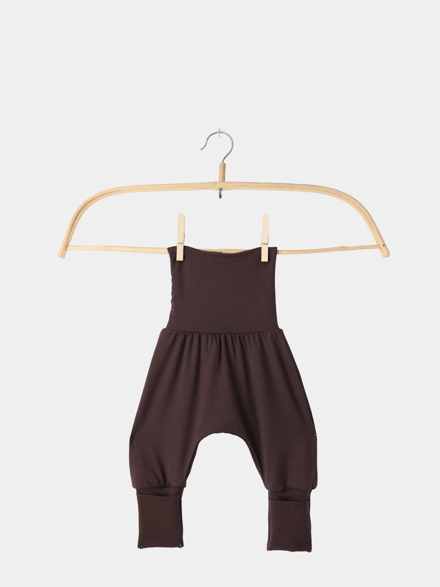 Babyknicker Bambusviskose Zartbitter: Holzkleiderbügel hält dunkelbraune Haremshose für Babys/Toddlers mit tiefem Schritt und zwei Wäscheklammern. Ideal für empfindliche Haut, weich und atmungsaktiv.
