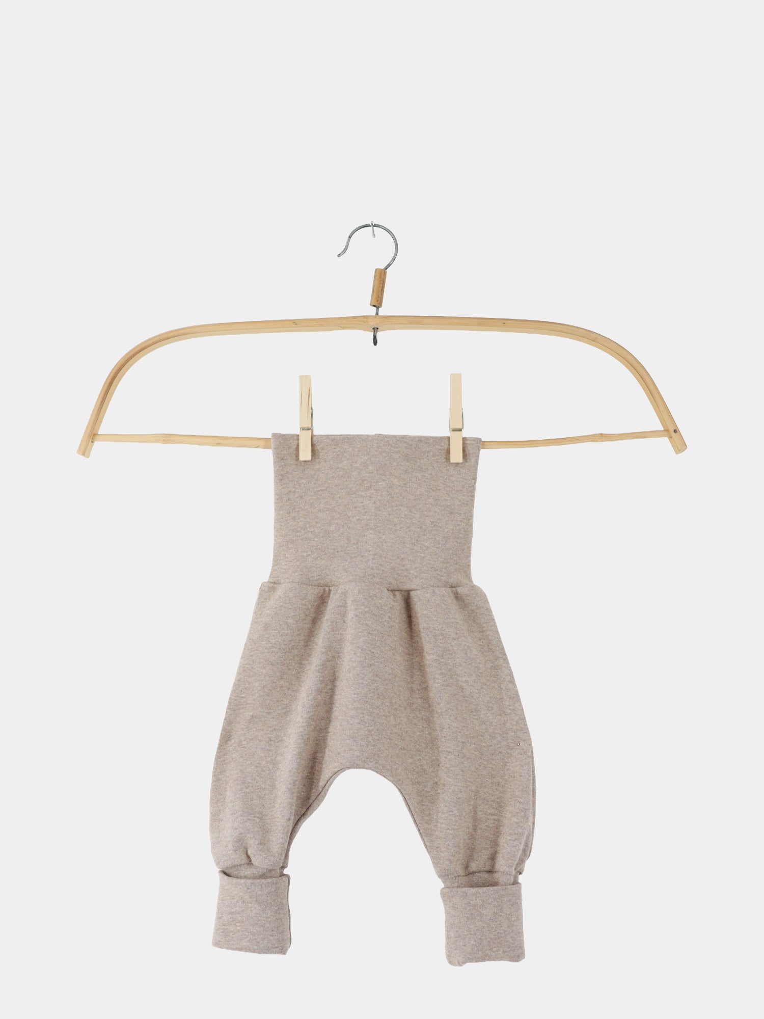 Babyknicker Feinstrick - Hafer Meliert: Ein leichter, drop-crotch Babystrampler aus meliertem Feinstrick-Jersey mit breitem, umklappbarem Bund und Bündchen an den Beinöffnungen, präsentiert auf einem Holzkleiderbügel.